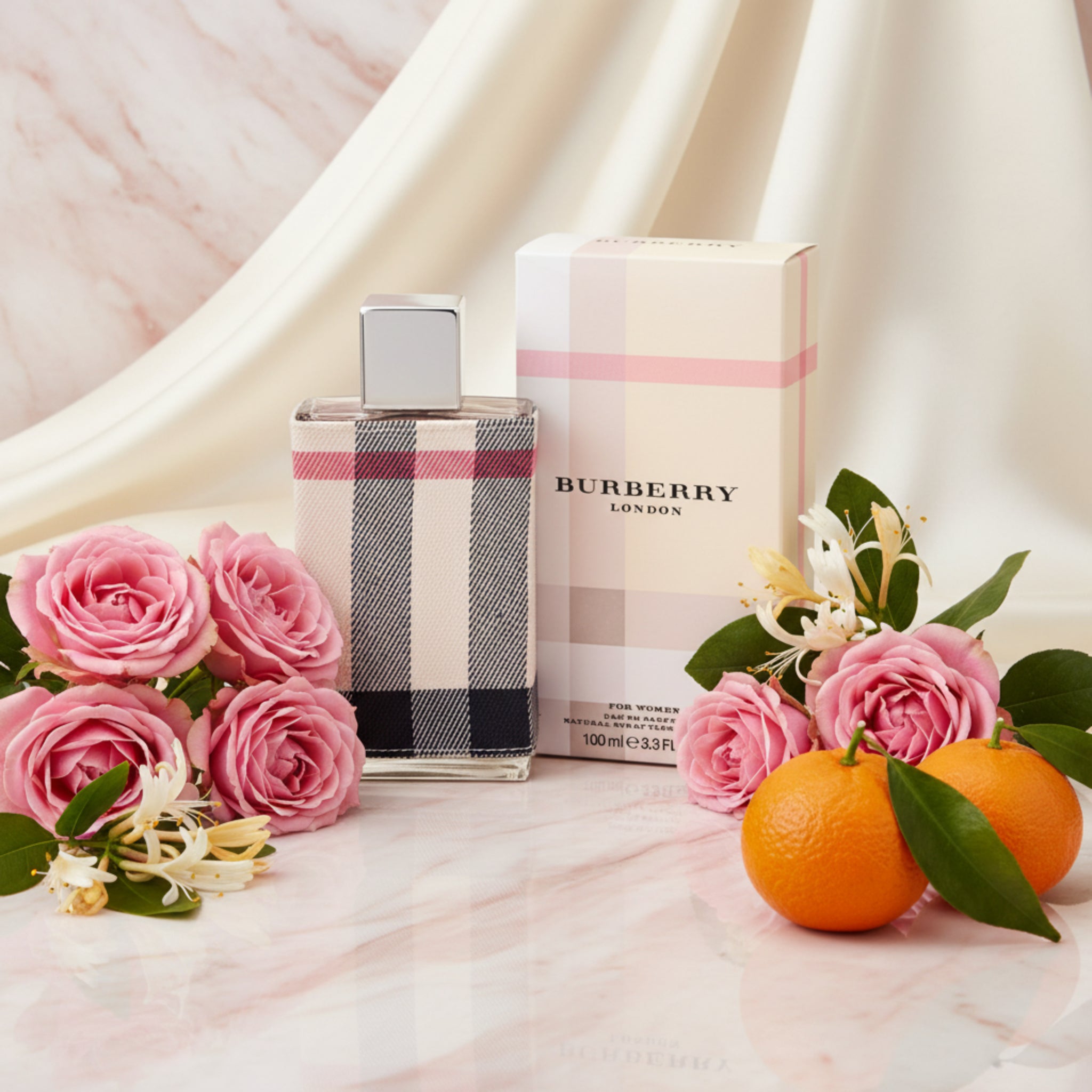 Burberry perfume bottle and packaging with checkered design on a white background