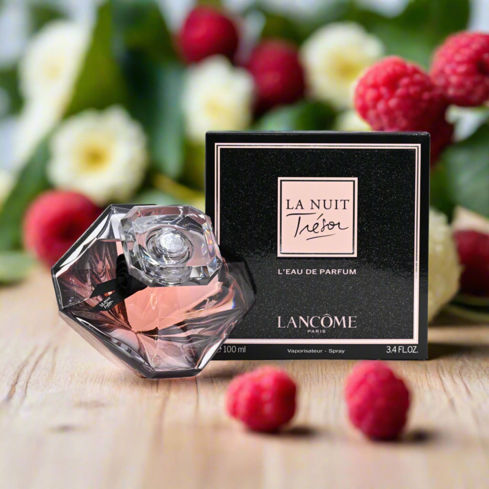 Lancome perfume bottle and packaging with raspberries and flowers in the background