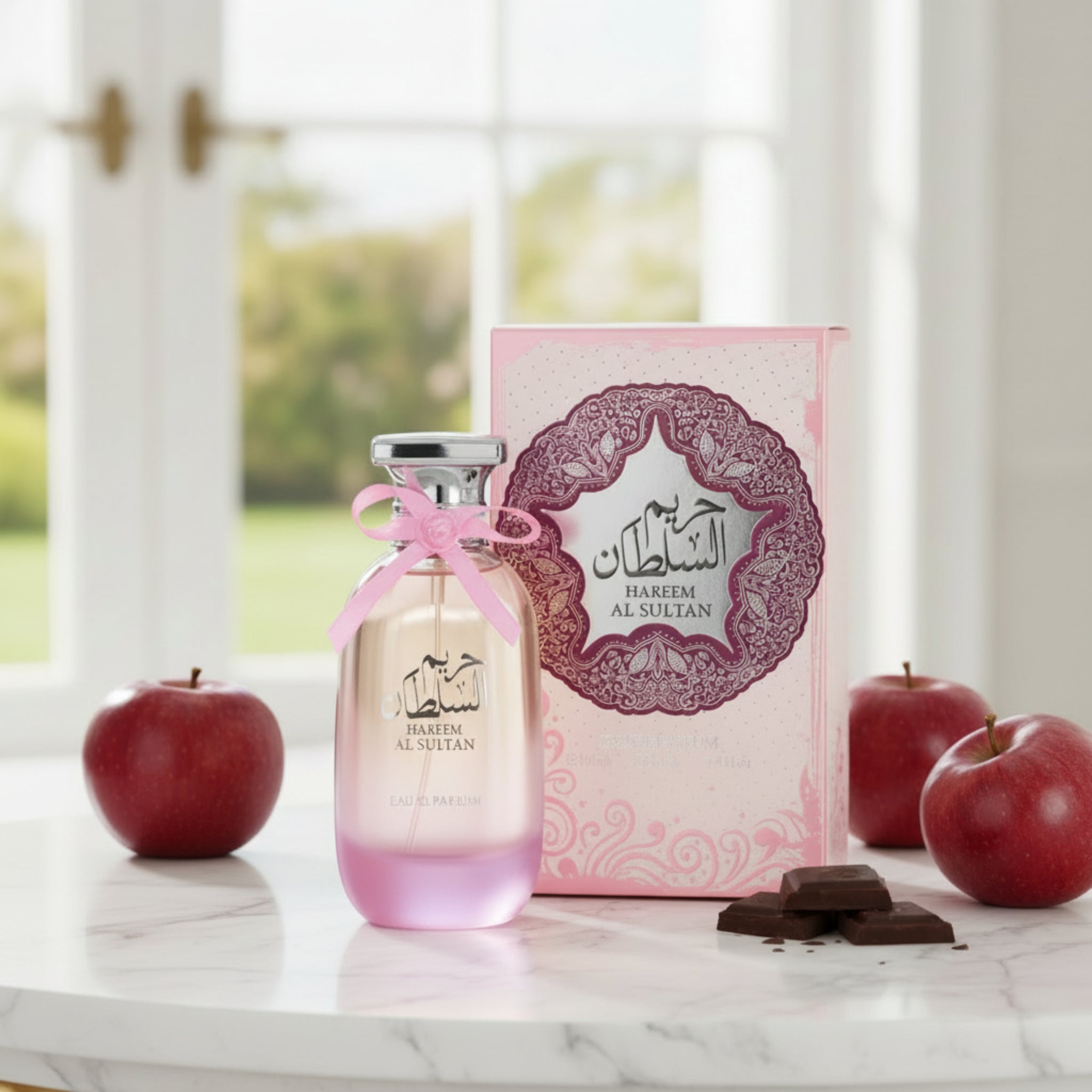 Perfume bottle with pink cap and decorative box featuring intricate design and text.