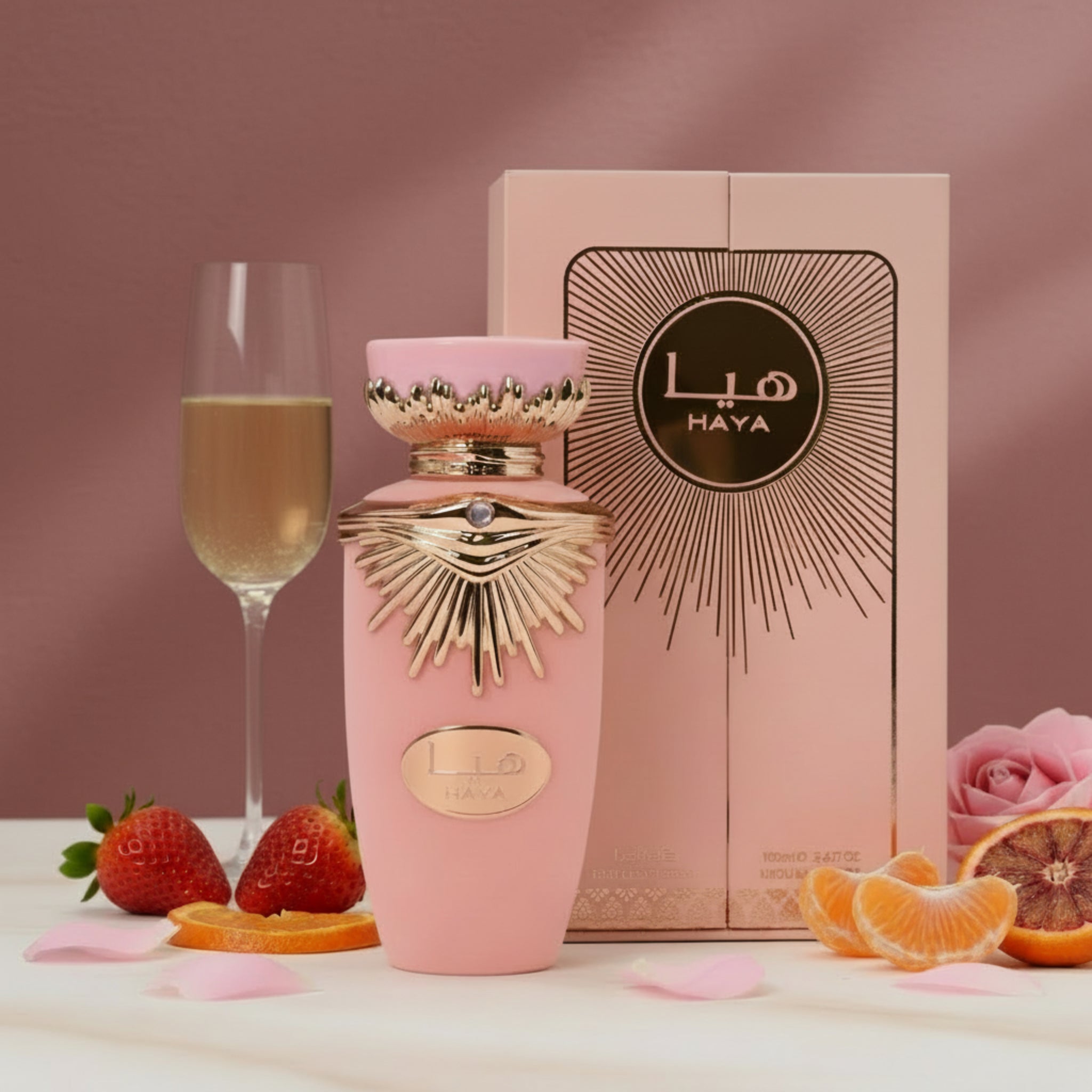 Pink and gold Lila Haya perfume bottle with packaging on a white background