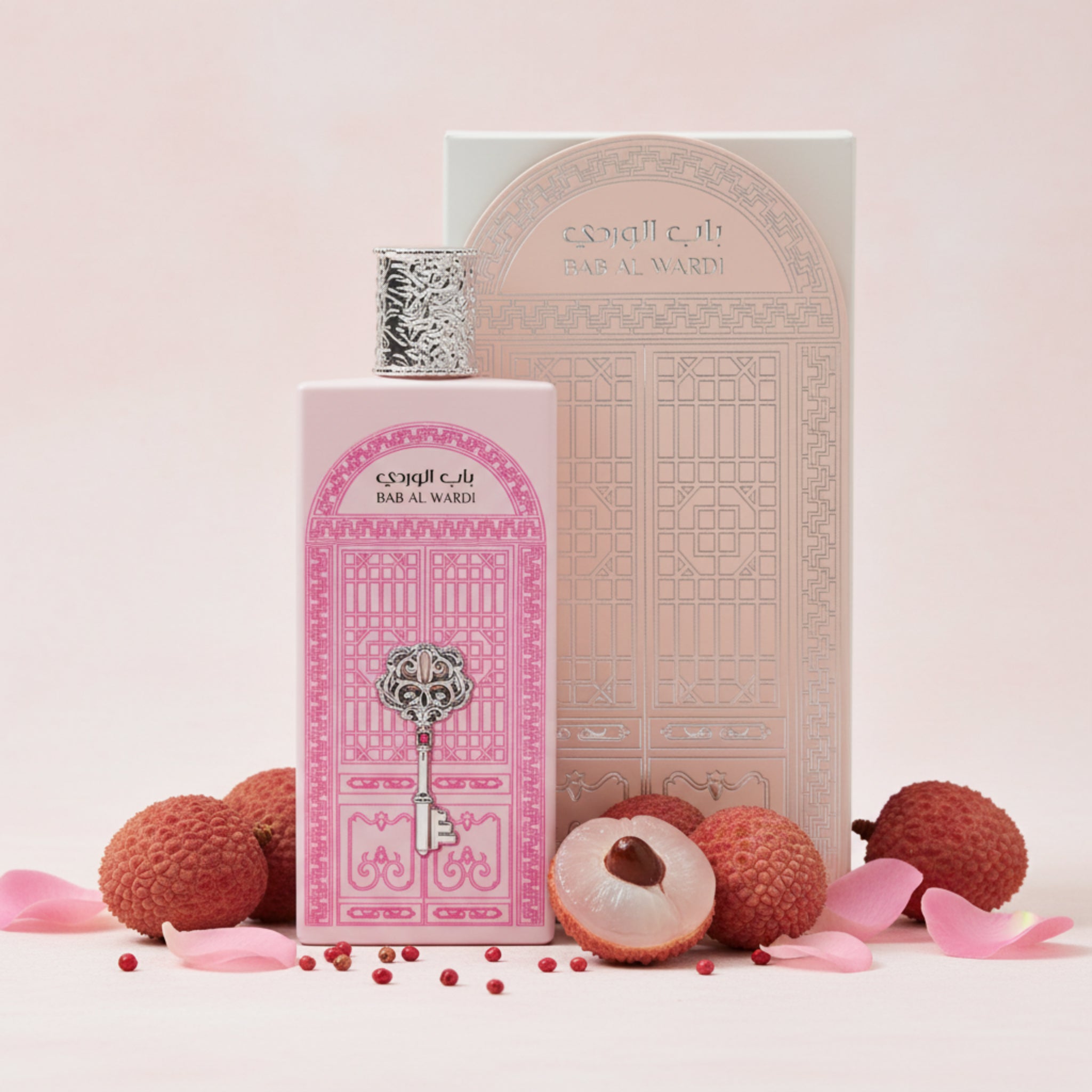 Perfume bottle and packaging with lychees and petals on a light pink background