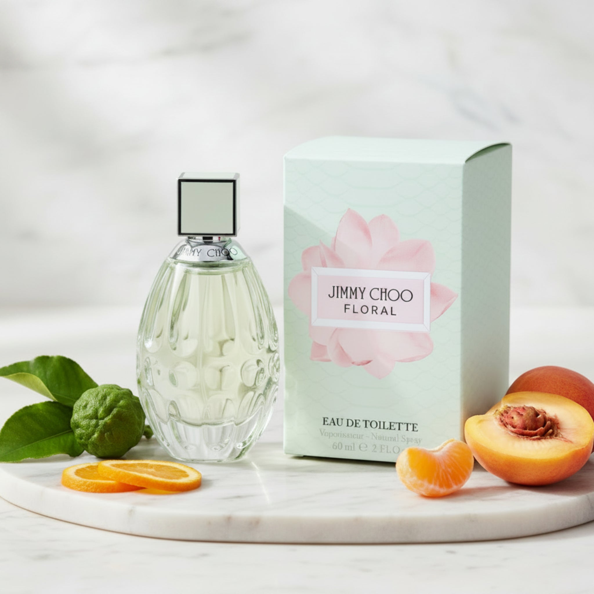 Jimmy Choo floral perfume bottle and packaging with fruits on a light background