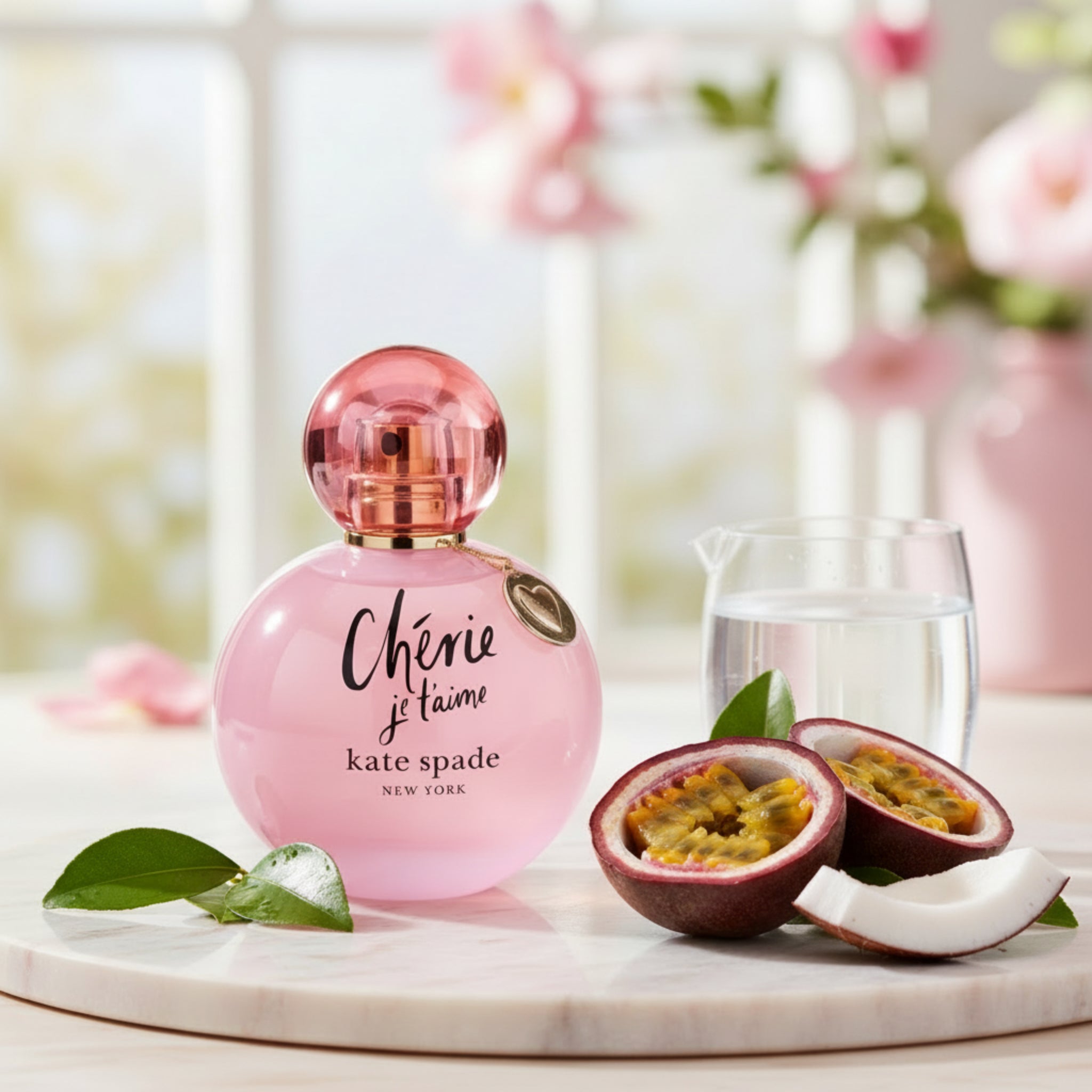 Pink perfume bottle with 'Chérie je t'aime' text and 'kate spade New York' branding on a white background.