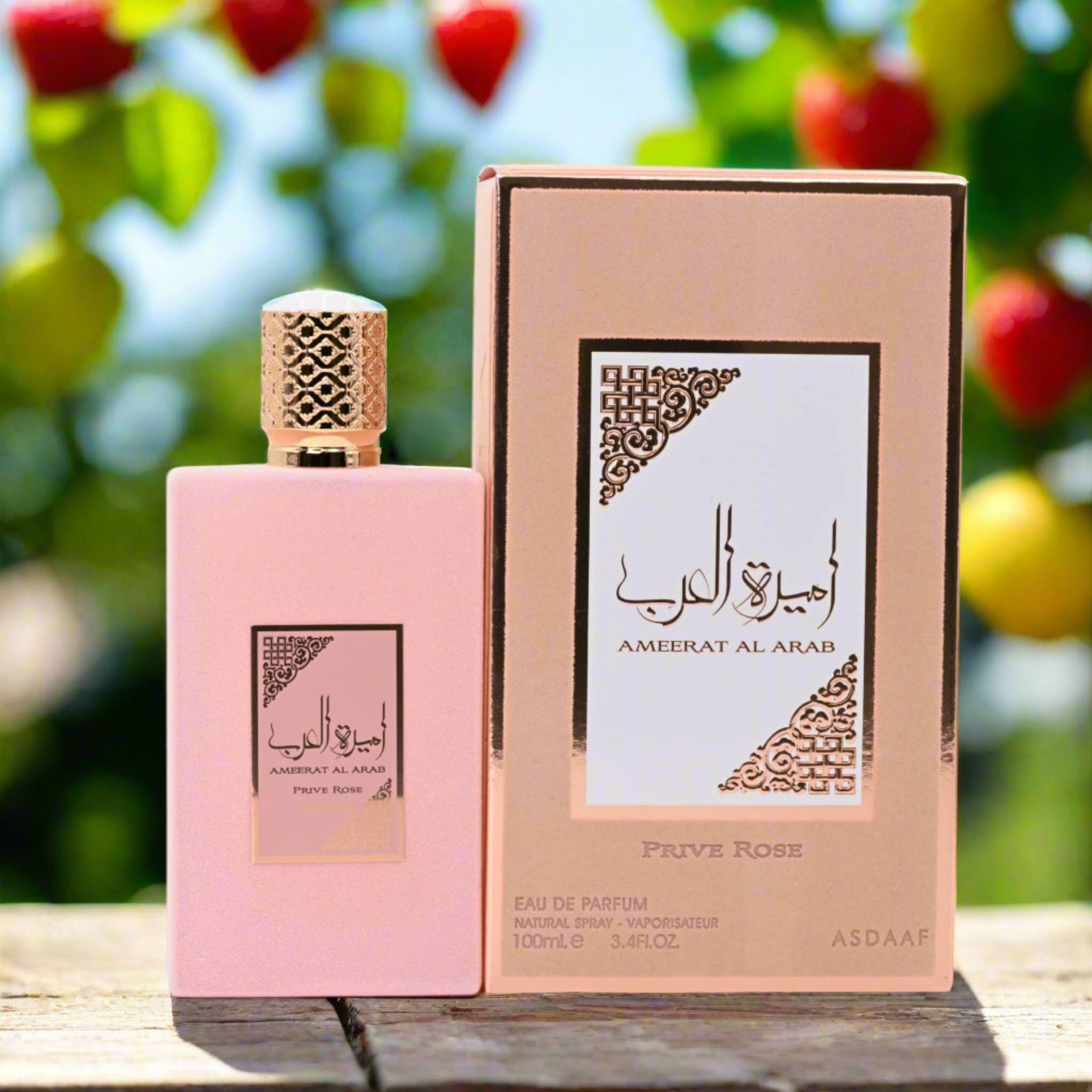 Pink perfume bottle and packaging with decorative design on a wooden surface with blurred natural background