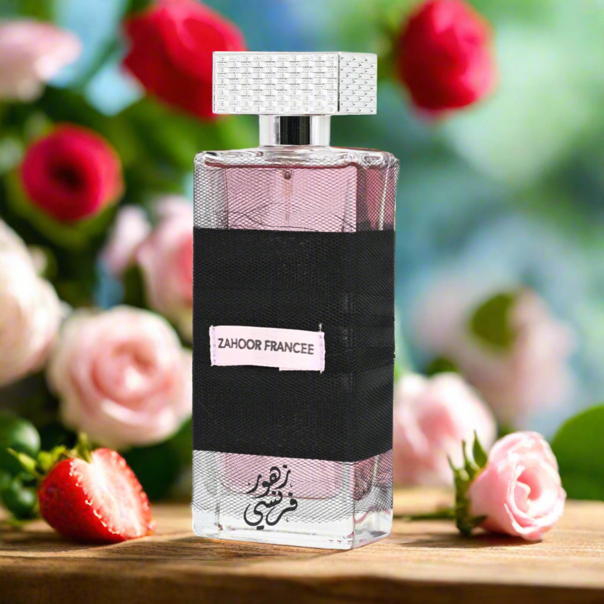 Perfume bottle with floral and fruit elements on a wooden surface