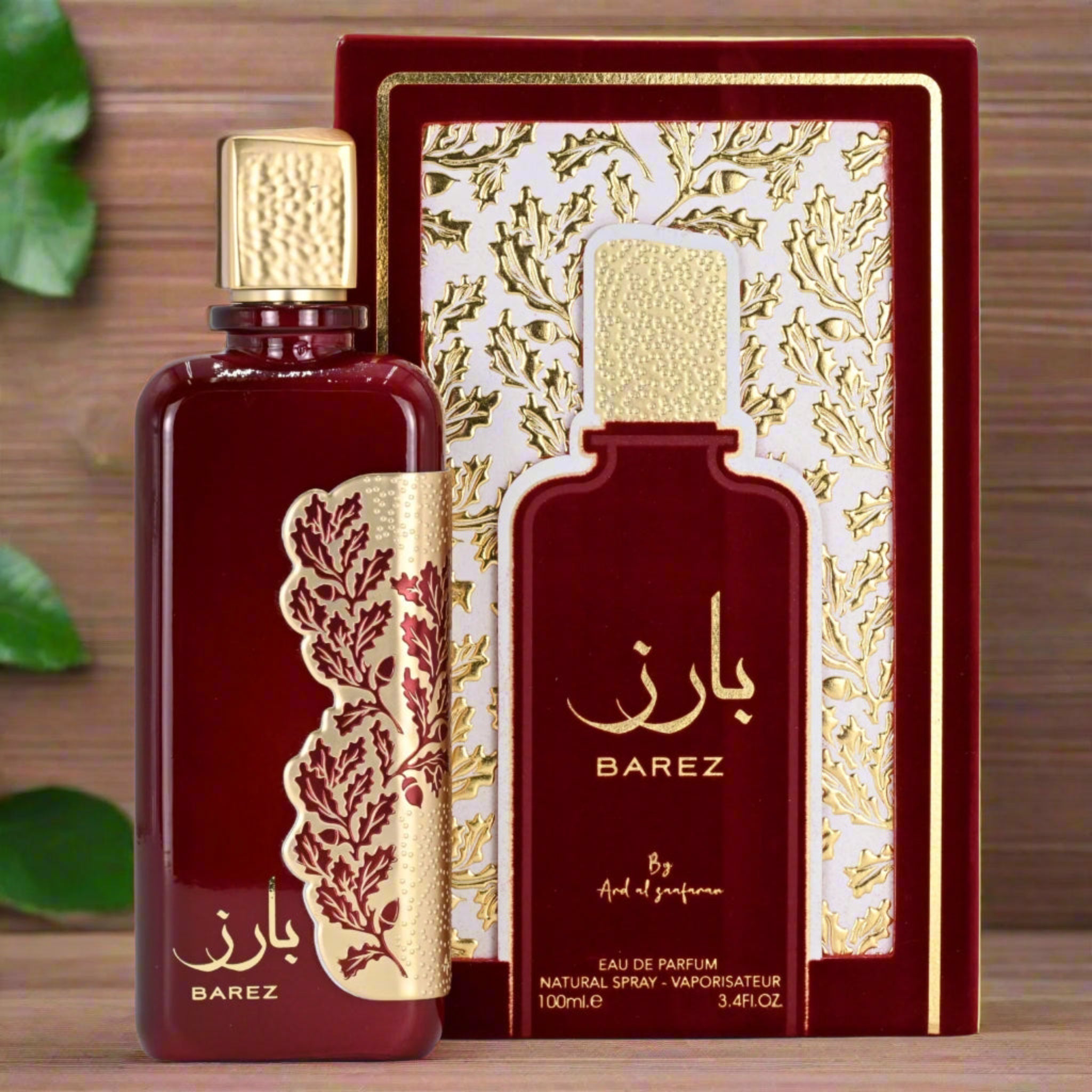BAREZ perfume bottle and packaging on a wooden surface with green leaves.