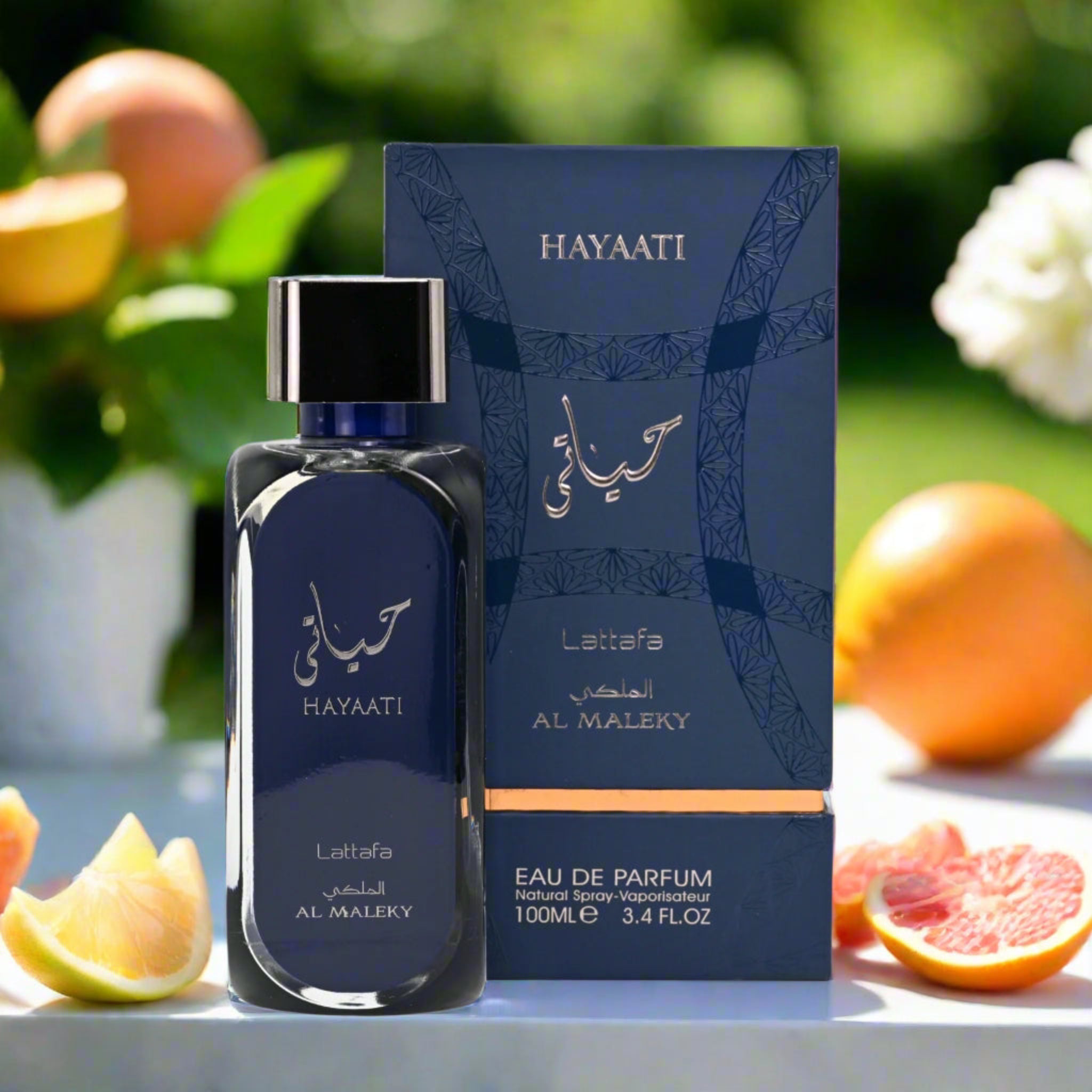 Hayaati Lattafa Al Maleky perfume bottle and packaging on a table with fruits in the background