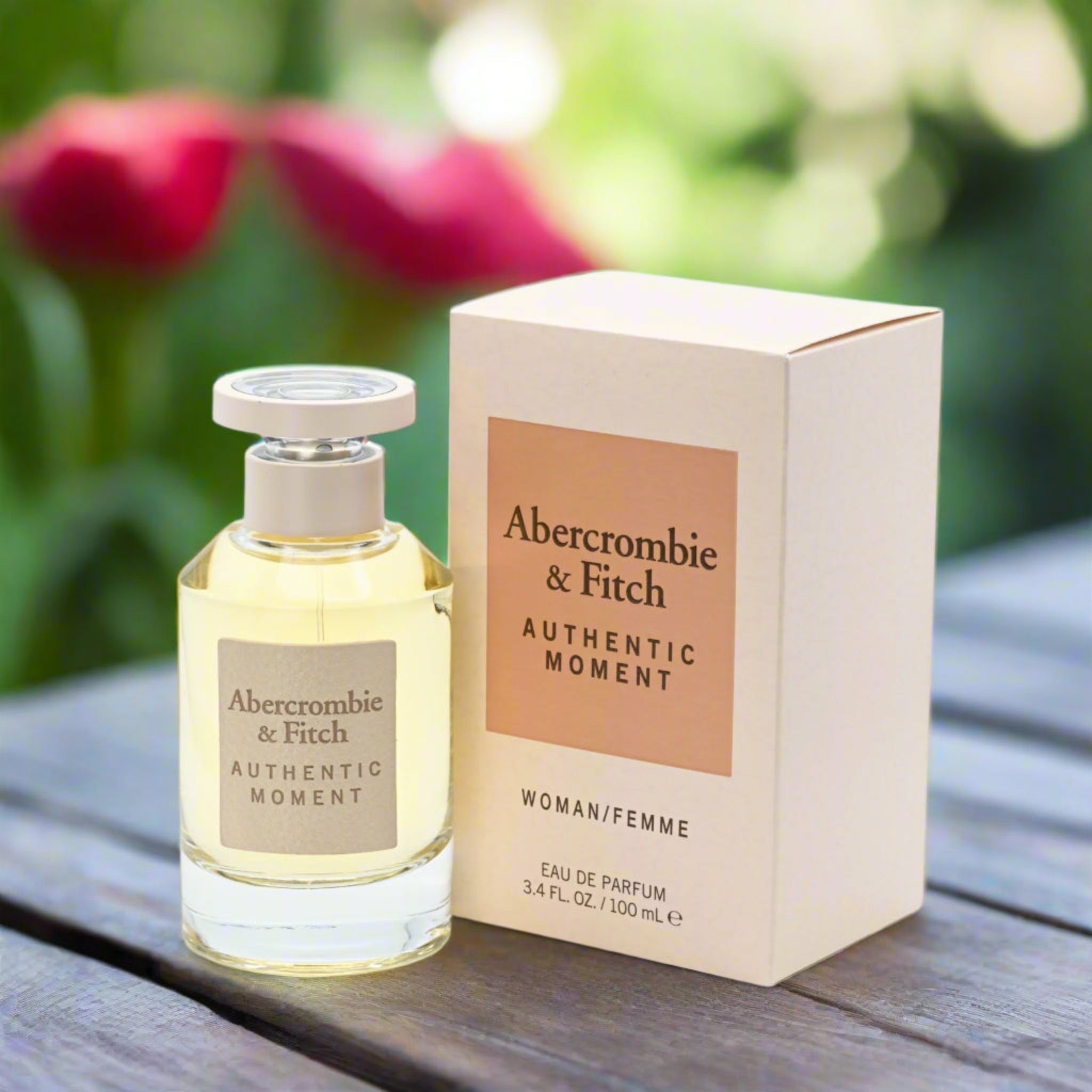 Abercrombie & Fitch perfume bottle and packaging on a wooden surface with flowers in the background
