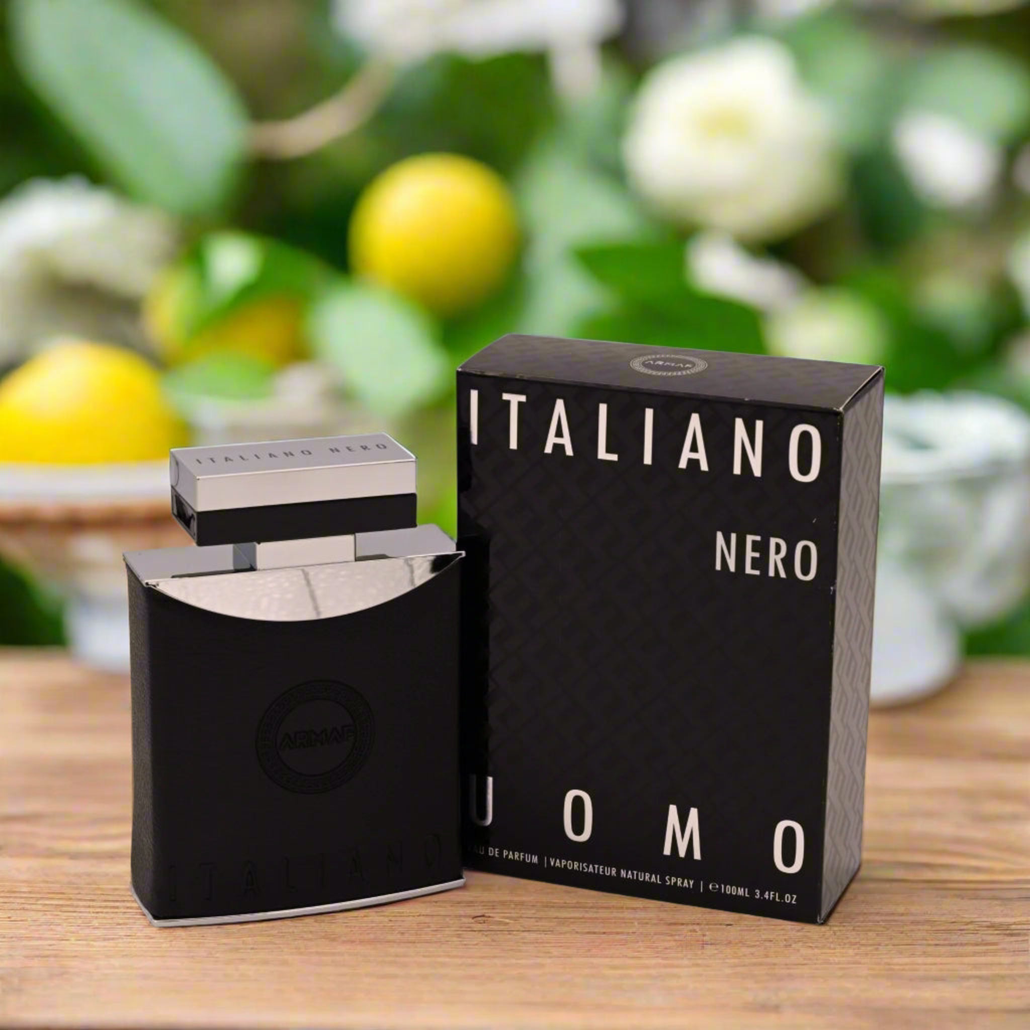 Black perfume bottles with 'Italiano Nero' packaging on a wooden surface with a blurred natural background.