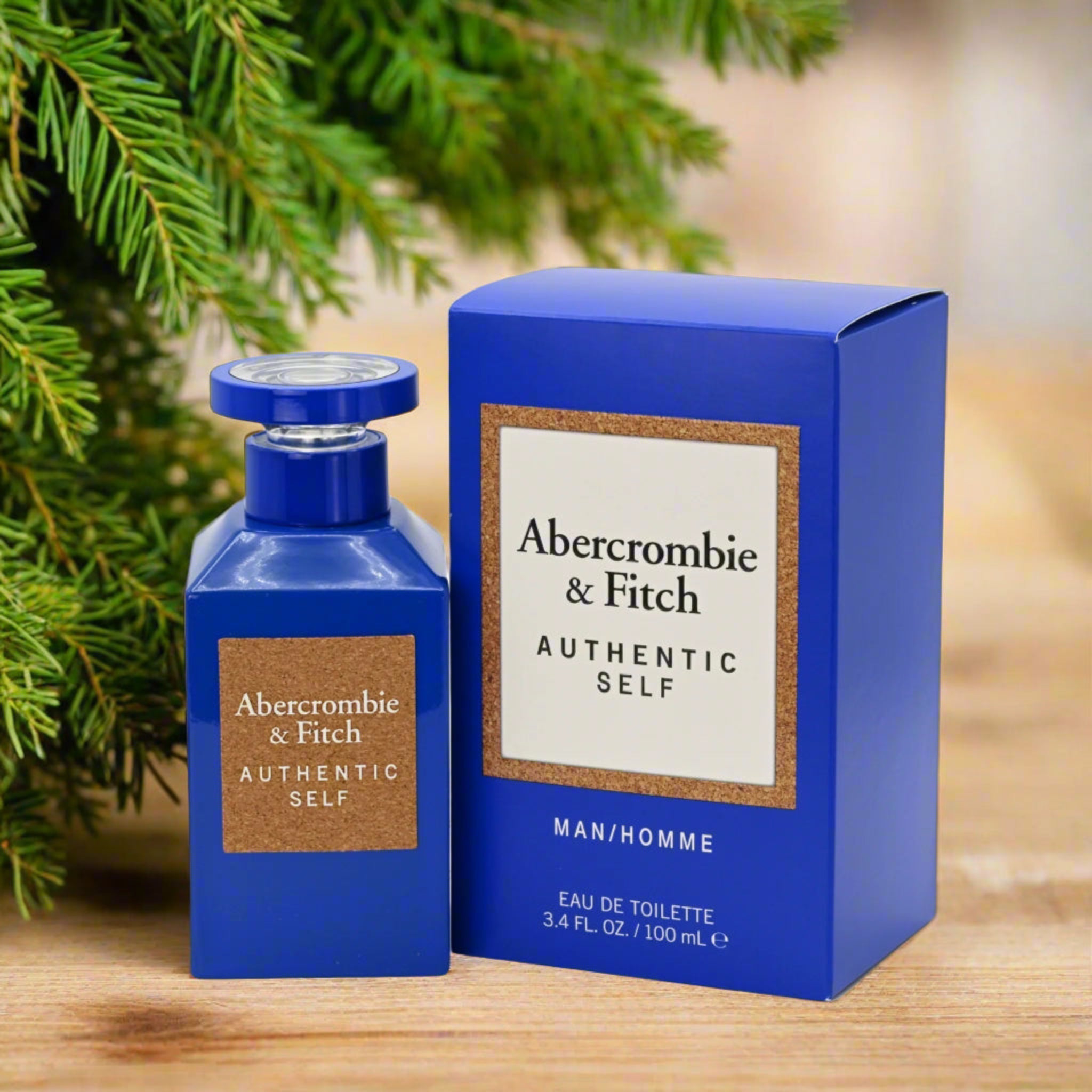 Abercrombie & Fitch perfume bottle and packaging on a wooden surface with greenery in the background