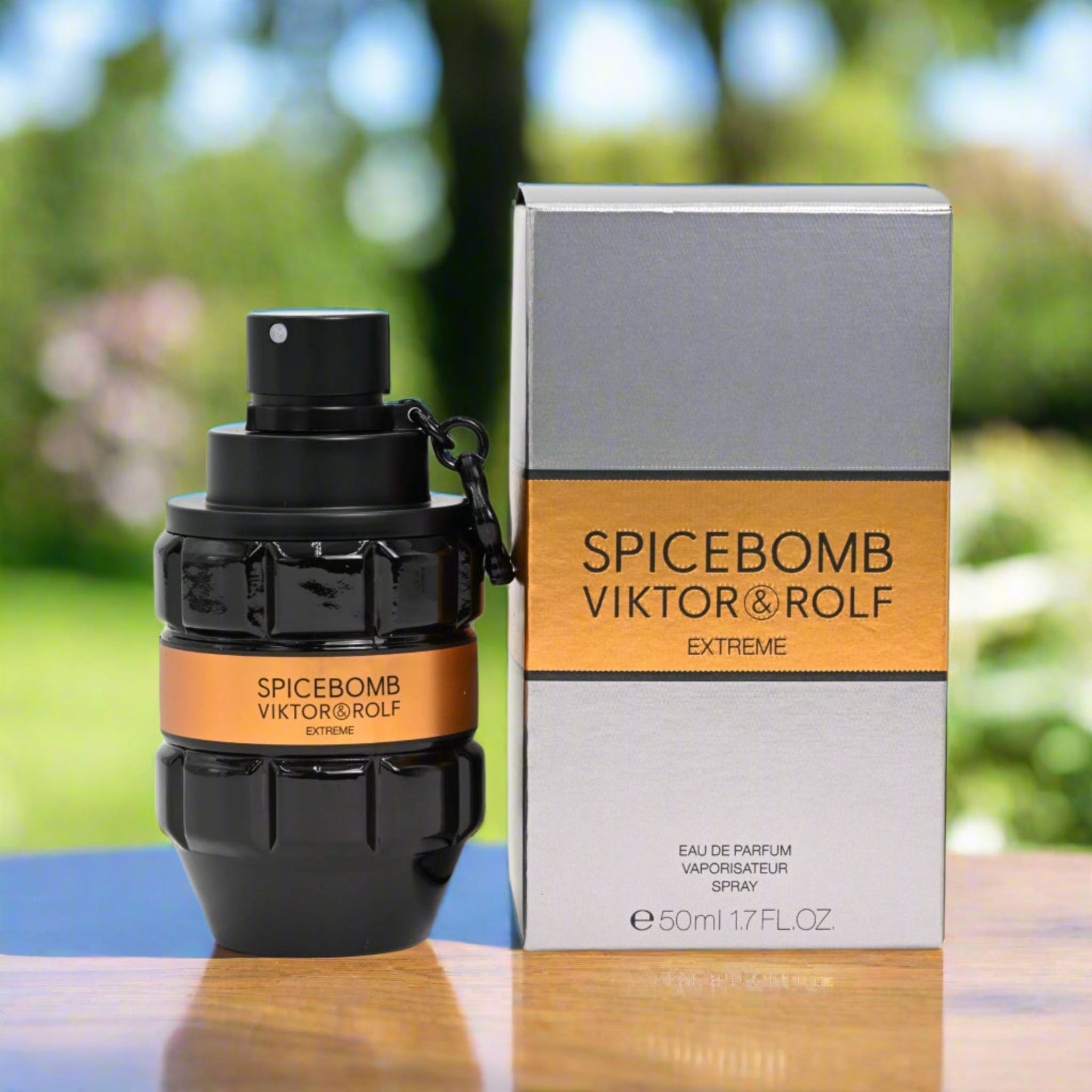 Spicebomb Viktor & Rolf Extreme perfume bottle and packaging on a table with a blurred green outdoor background
