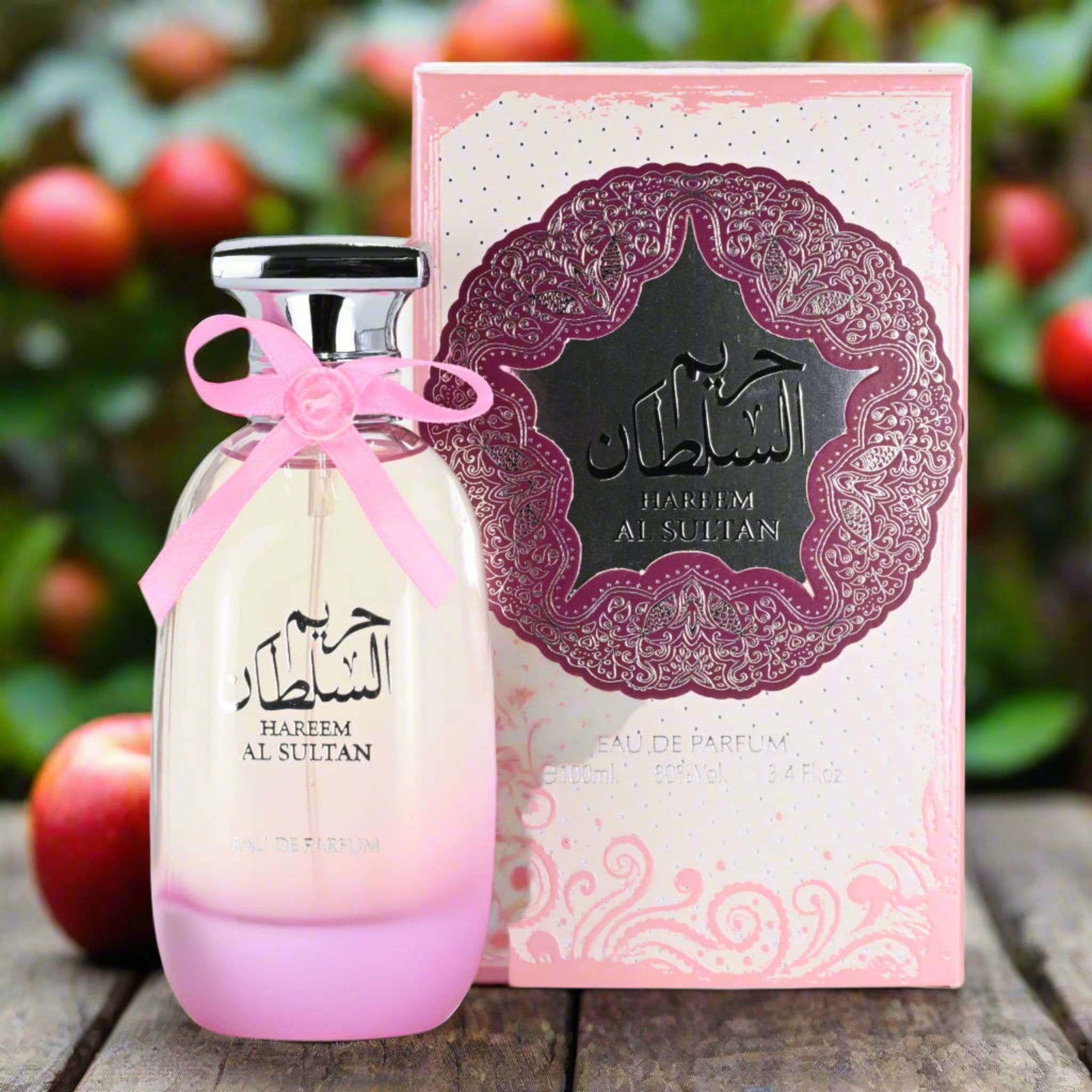 Perfume bottle and packaging with decorative elements on a wooden surface with apples in the background
