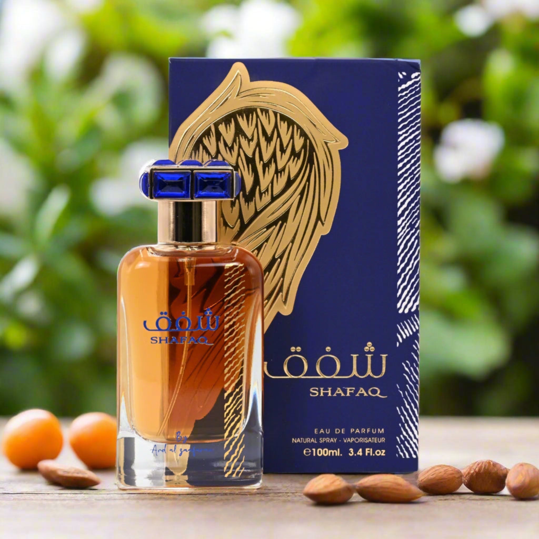 Shafaq perfume bottle and packaging with almonds on a wooden surface and blurred green background