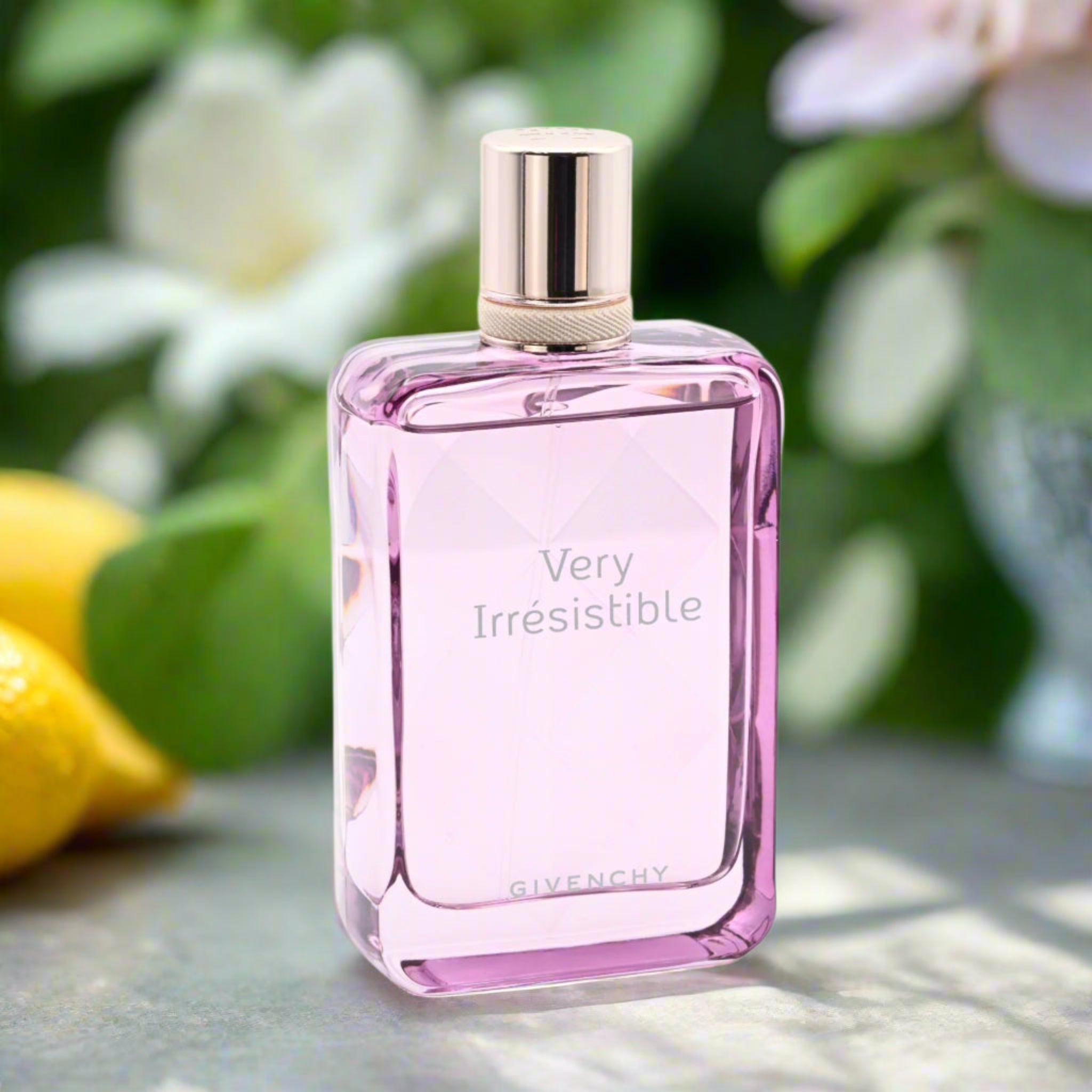 Pink Givenchy perfume bottle labeled 'Very Irresistible' with a floral background