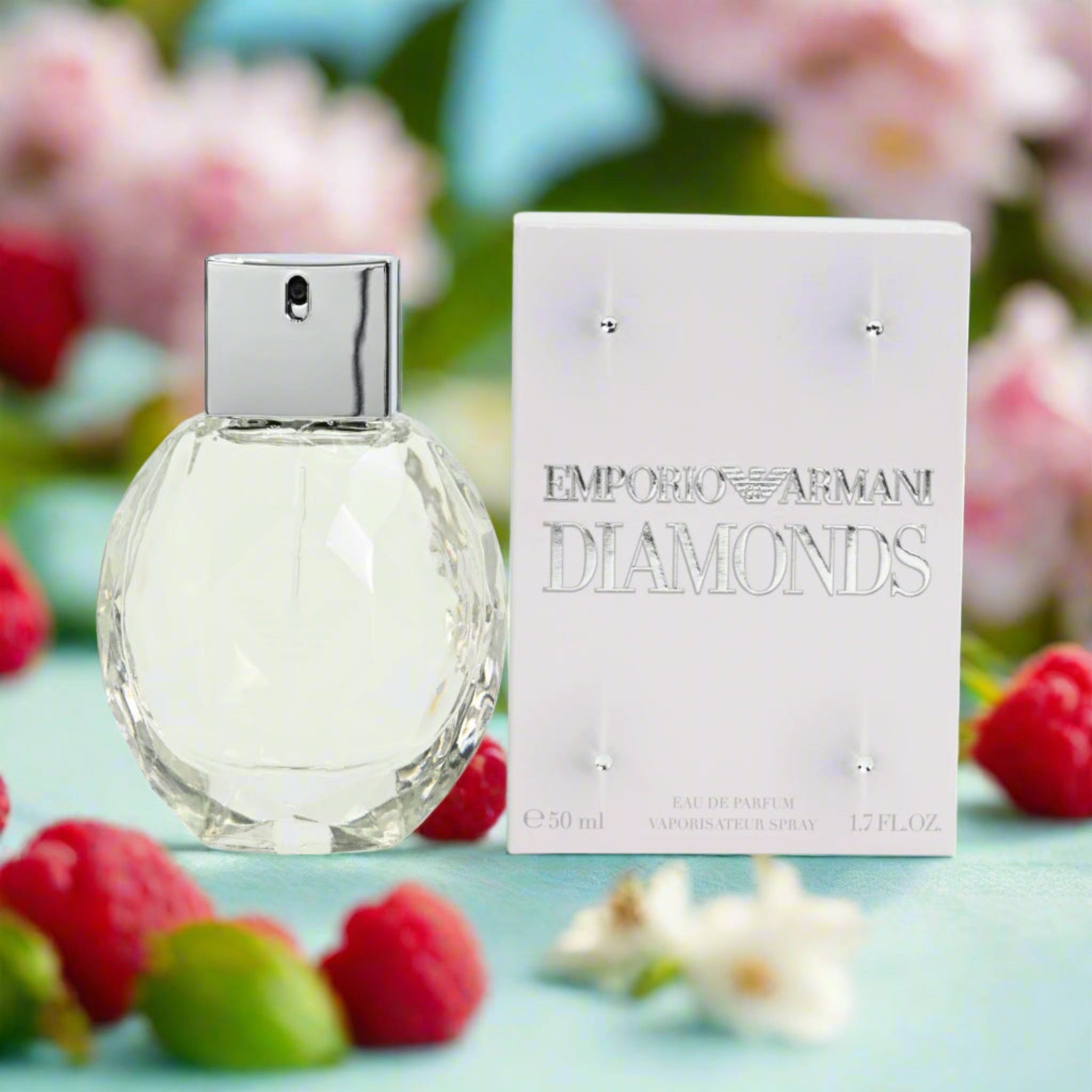 Emporio Armani Diamonds perfume bottle and packaging with raspberries and flowers in the background
