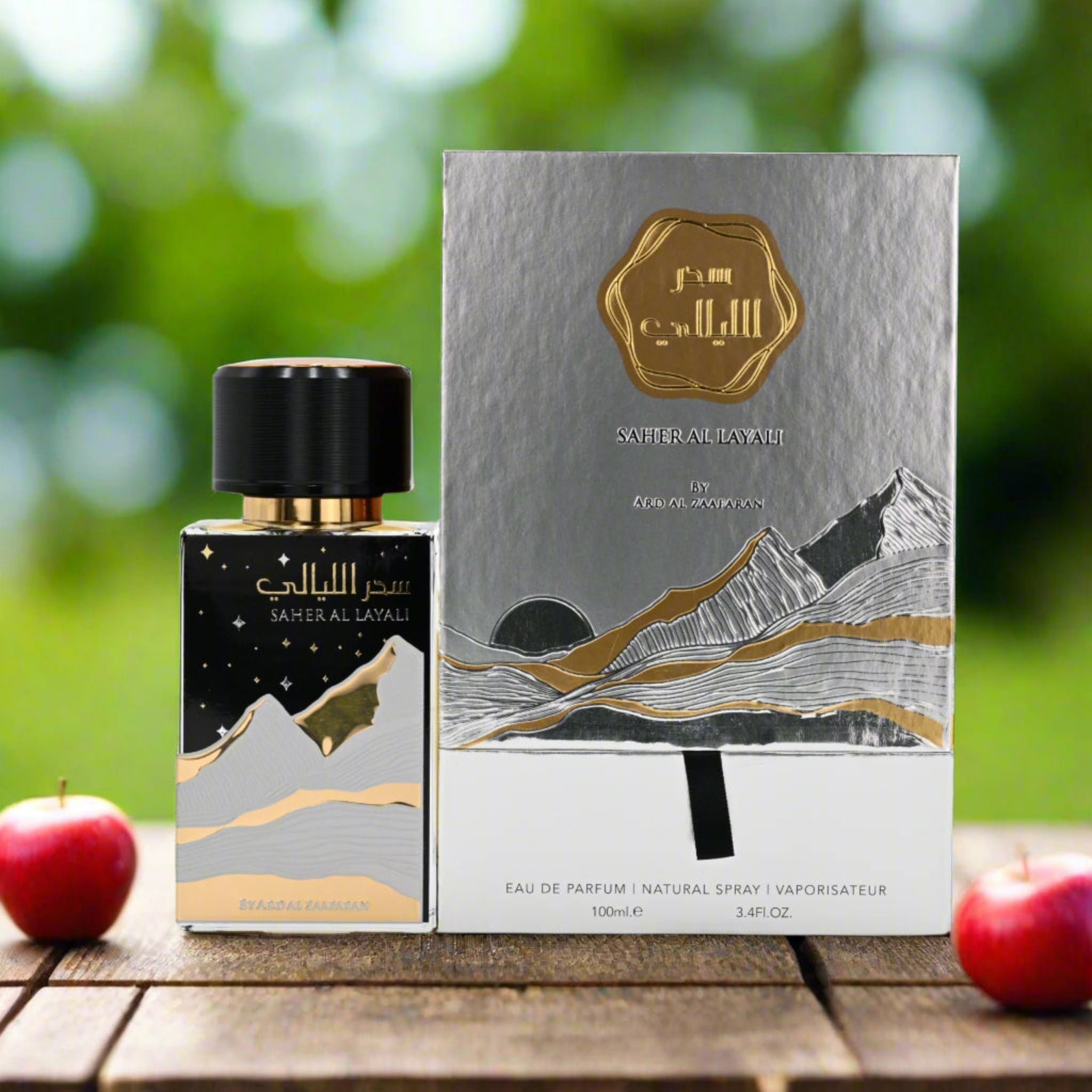 Saher Al Layali perfume bottle and packaging on a wooden surface with a blurred green background