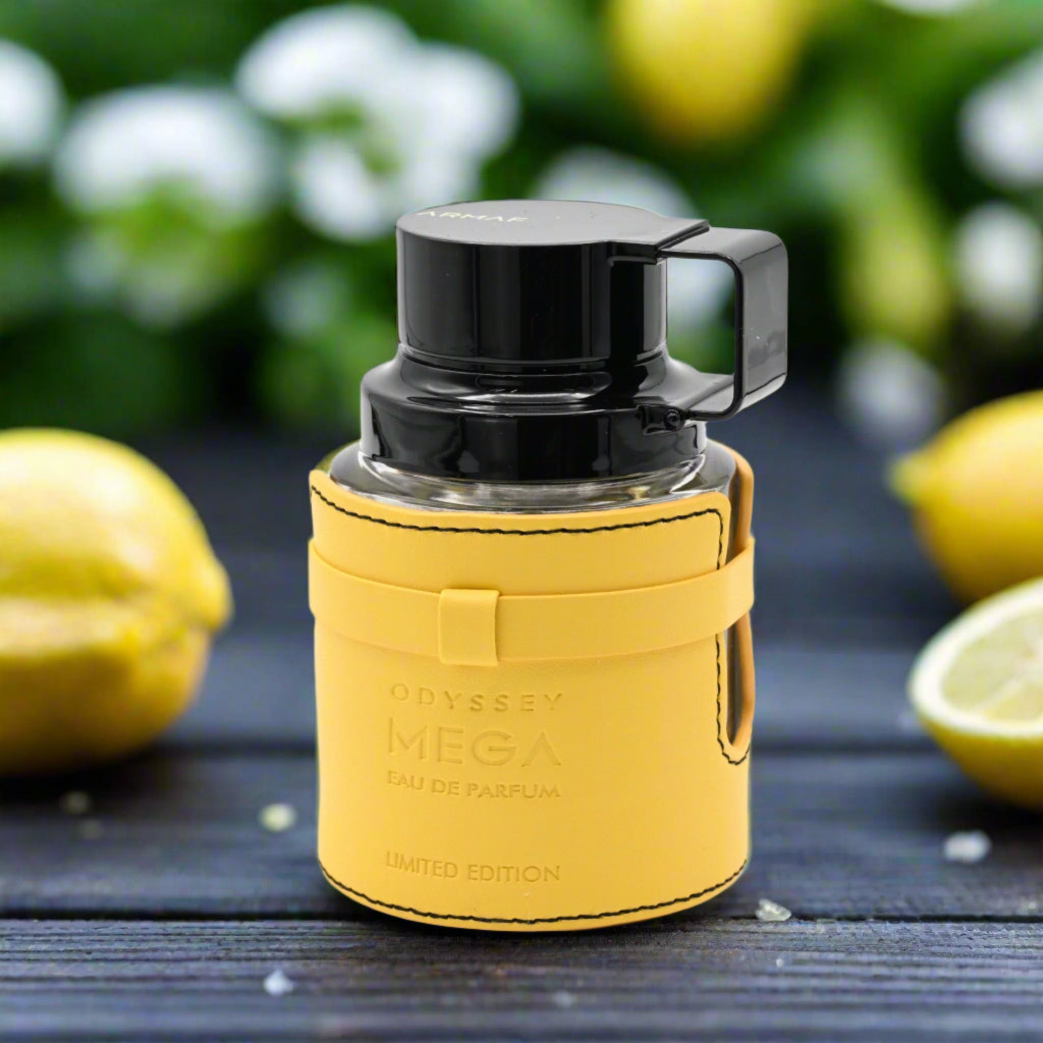 Yellow perfume bottle with black cap on a dark surface with lemons in the background