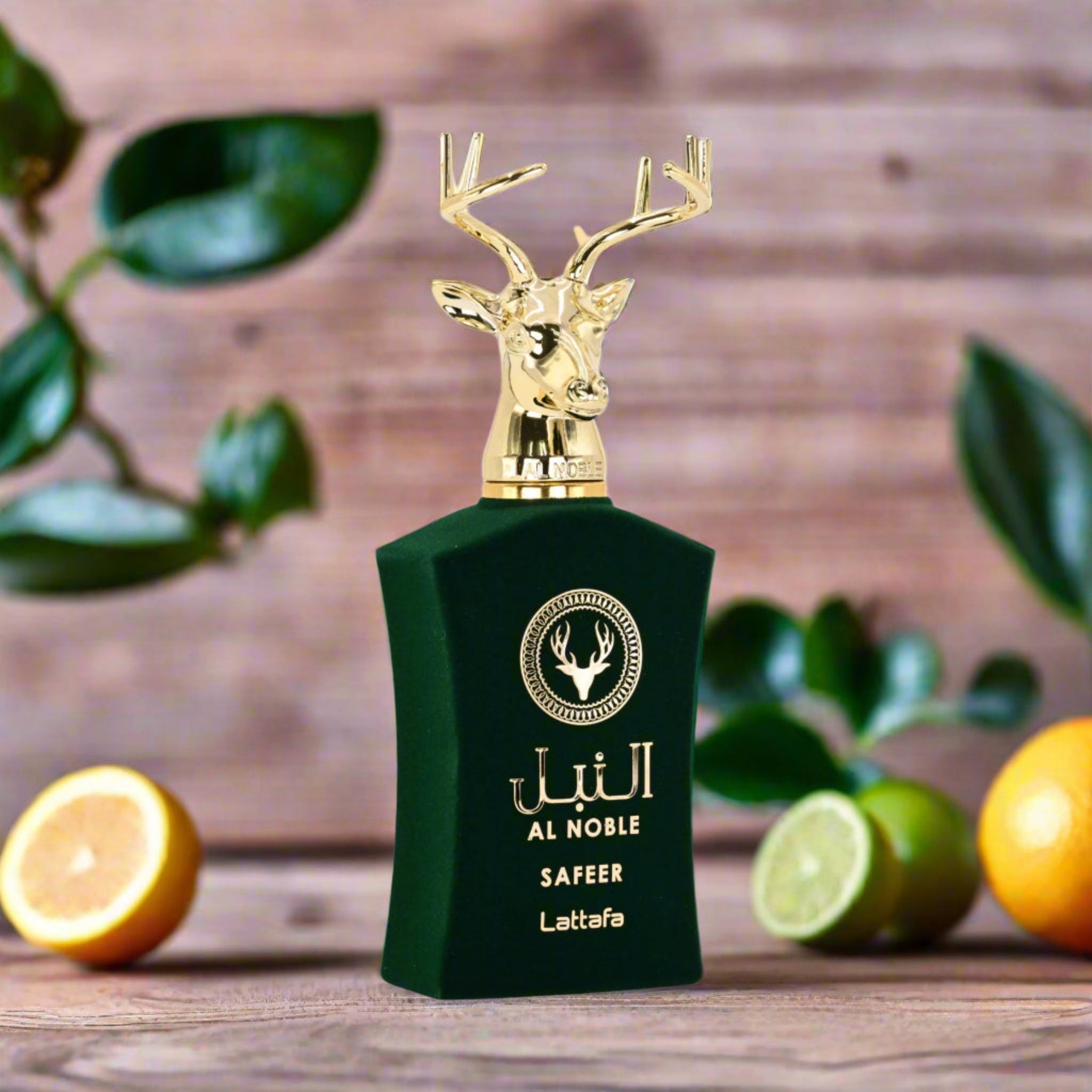 Green perfume bottle with gold deer design on a wooden surface with fruits and leaves.