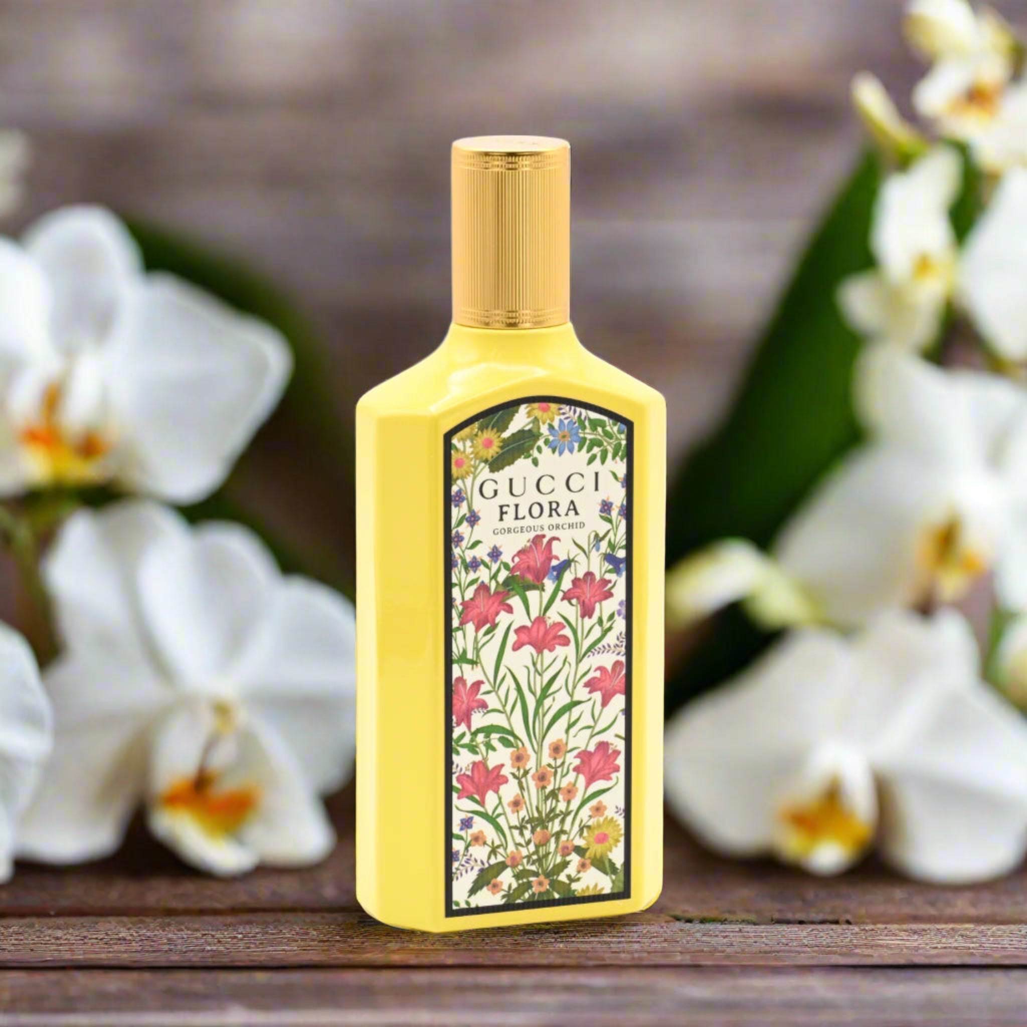 Gucci Flora perfume bottle with floral design on a wooden surface with white flowers in the background