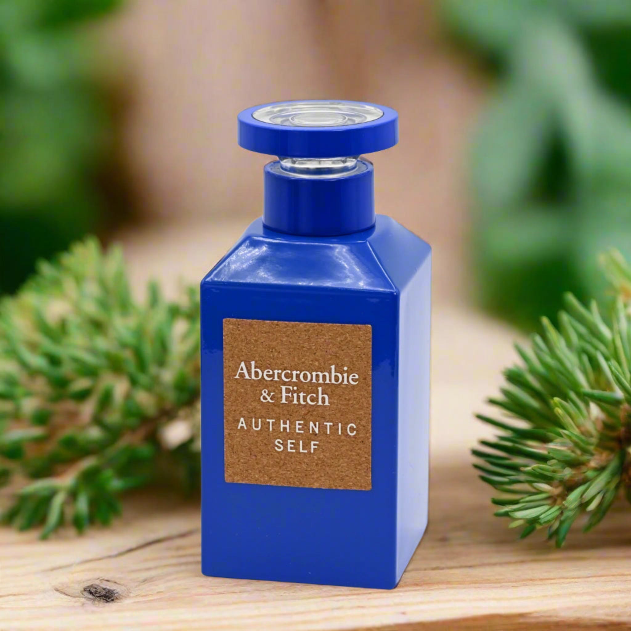 Blue Abercrombie & Fitch perfume bottle with green foliage in the background