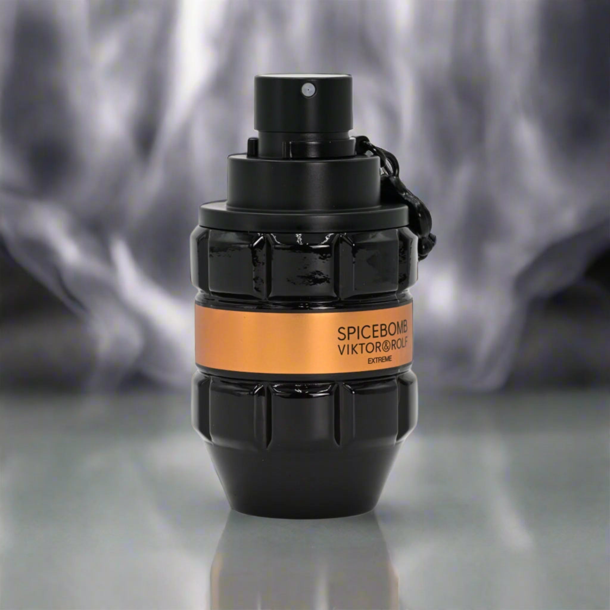 Black and orange perfume bottle with 'Spicebomb' text on a reflective surface.