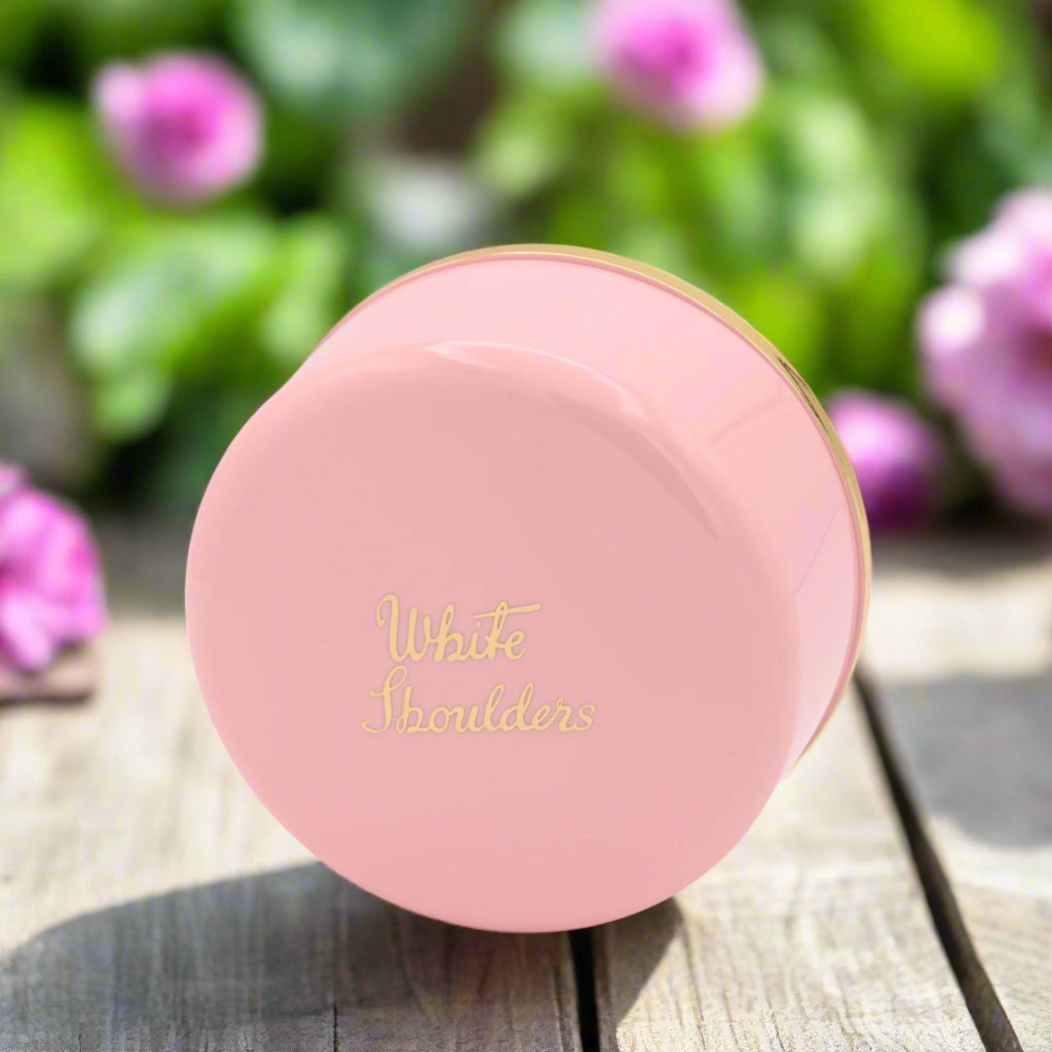 Pink compact powder with 'White Shoulders' text on a white background
