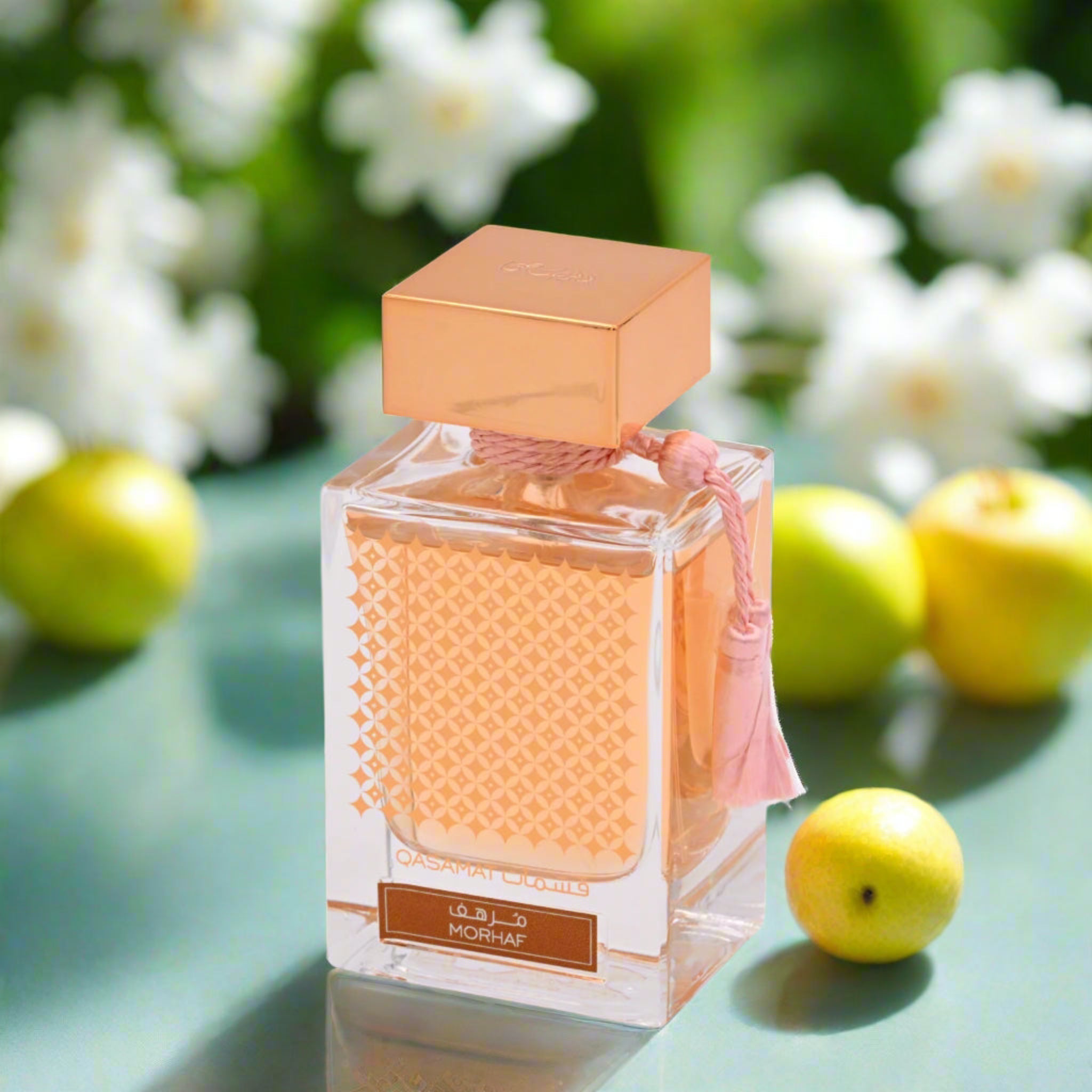 Perfume bottle with a textured design on a green surface with fruits and flowers in the background