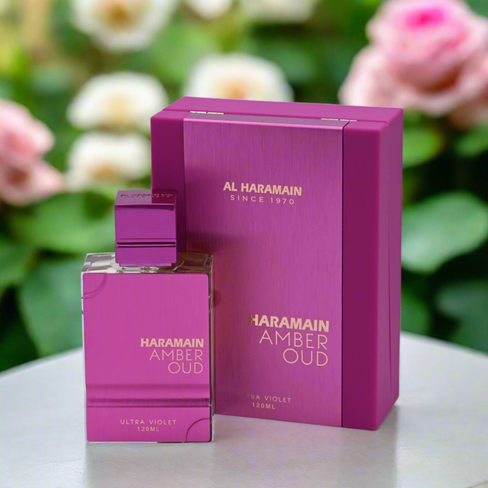 Haramain Amber Oud perfume bottle and packaging with flowers in the background