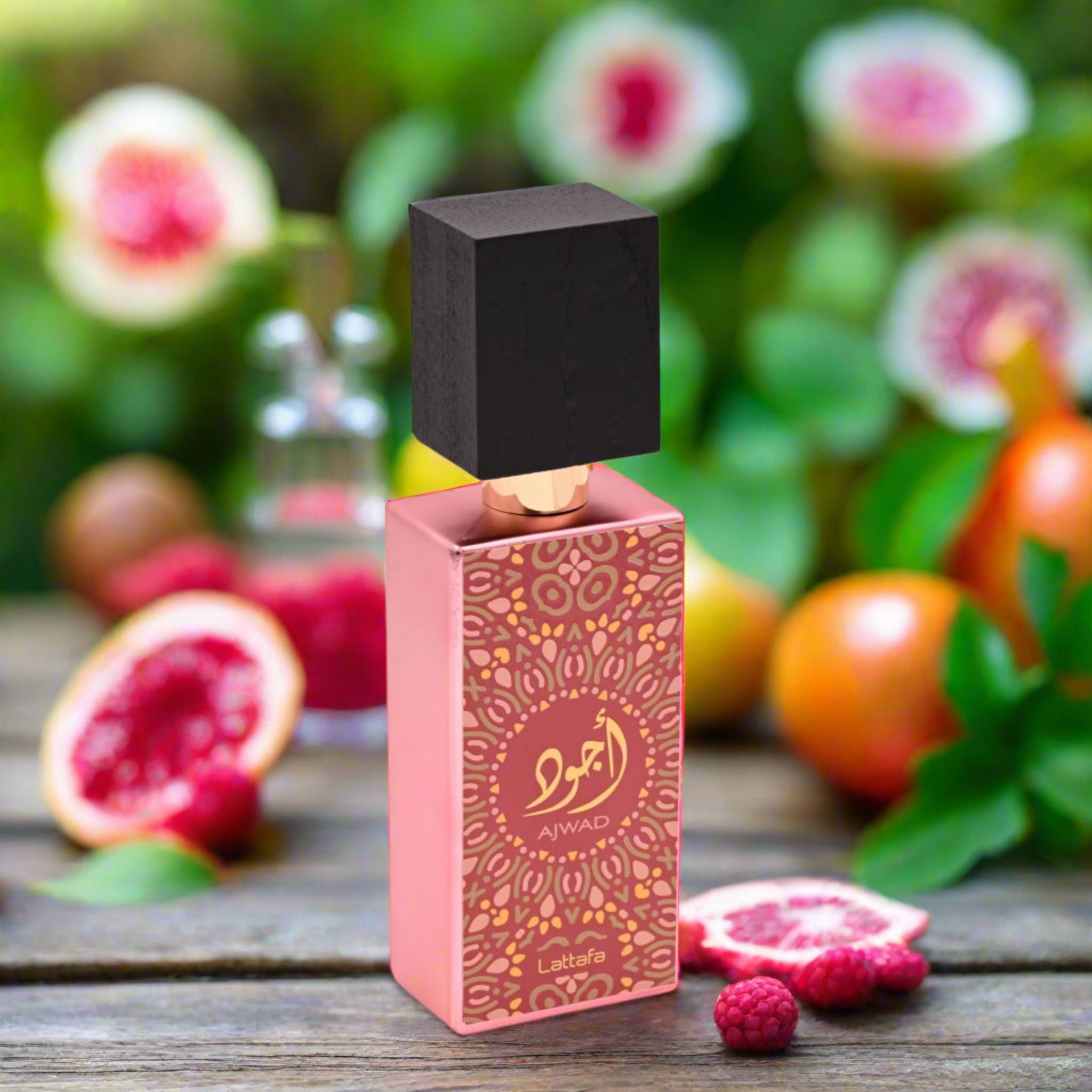 Perfume bottle with pink packaging on a wooden surface with fruits and flowers in the background