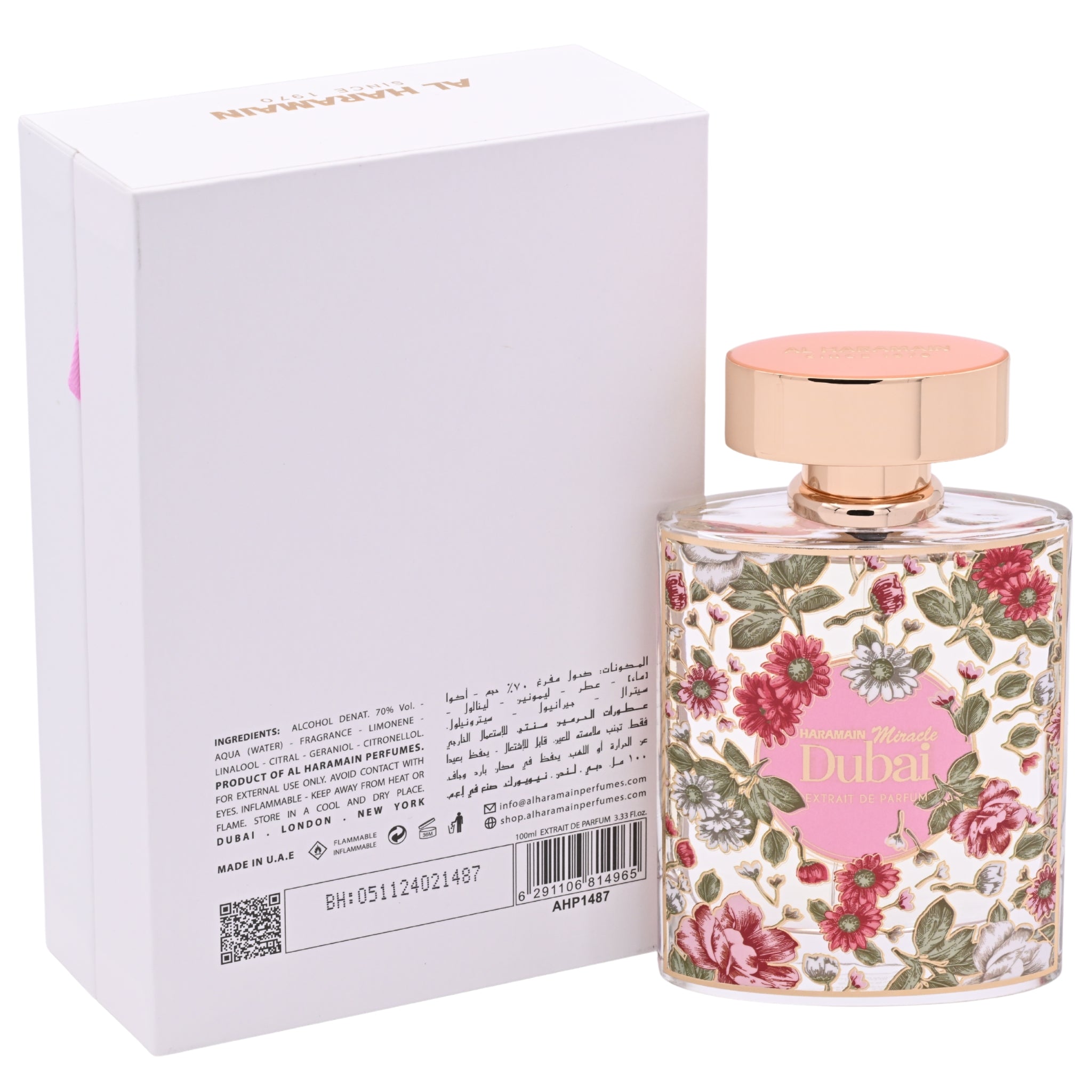 Perfume bottle with floral design and pink cap next to its packaging on a white background