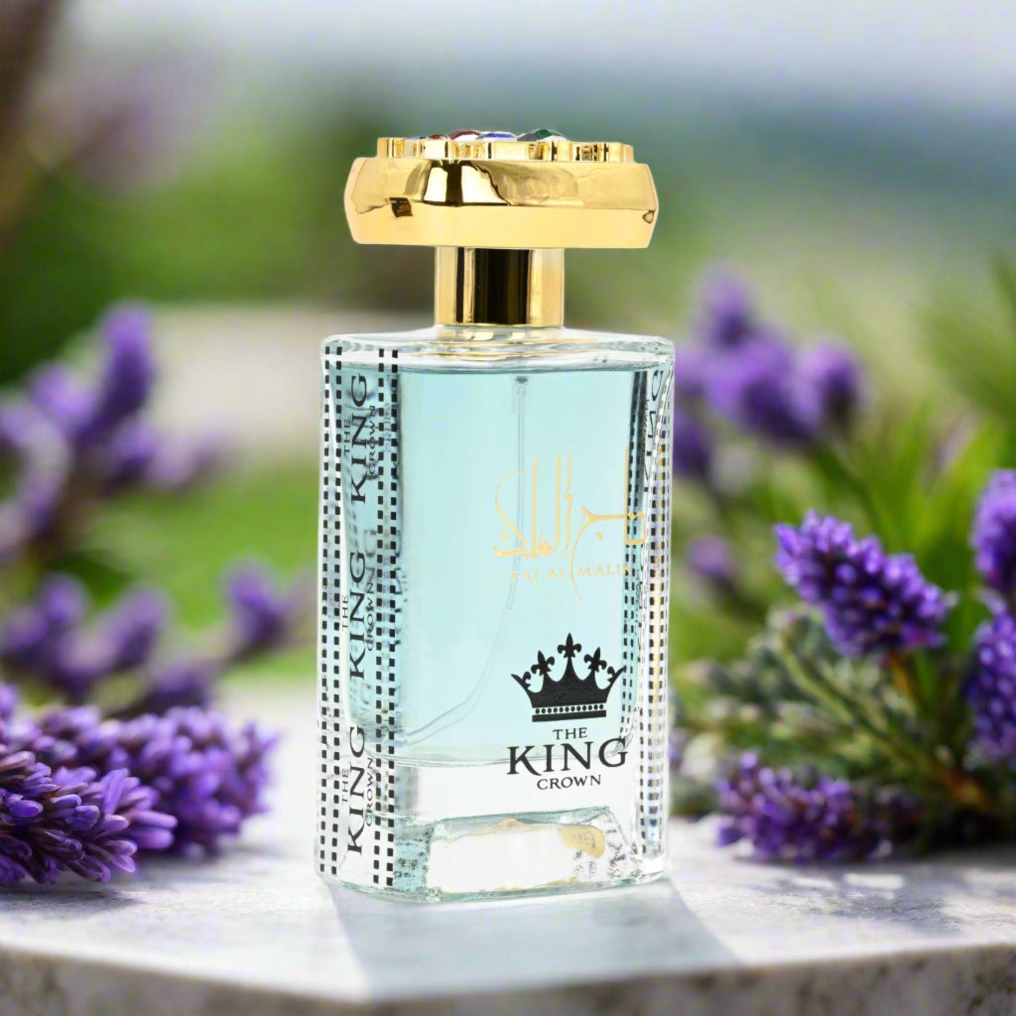 Perfume bottle with gold cap and 'The King Crown' branding surrounded by lavender flowers.