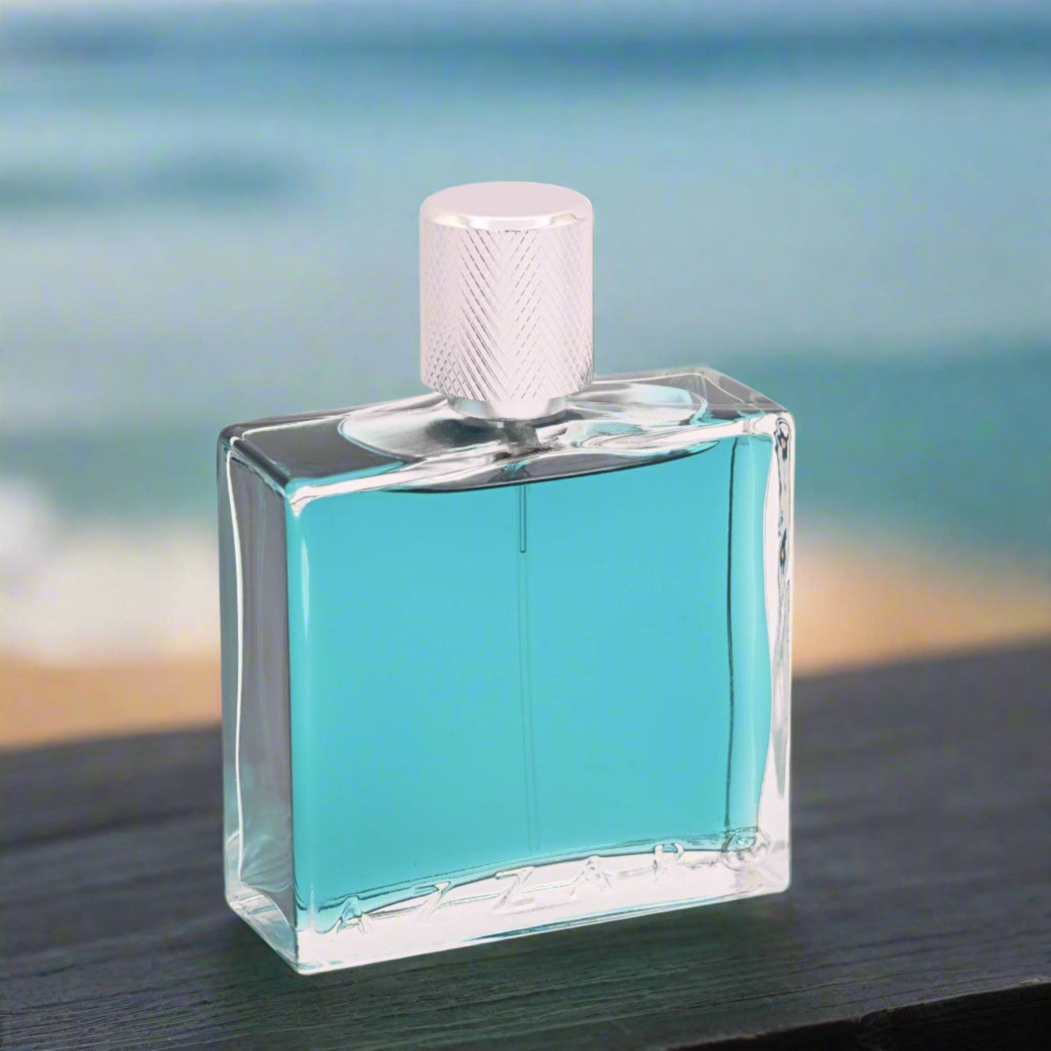 Clear glass bottle with blue liquid and white cap on a blurred beach background