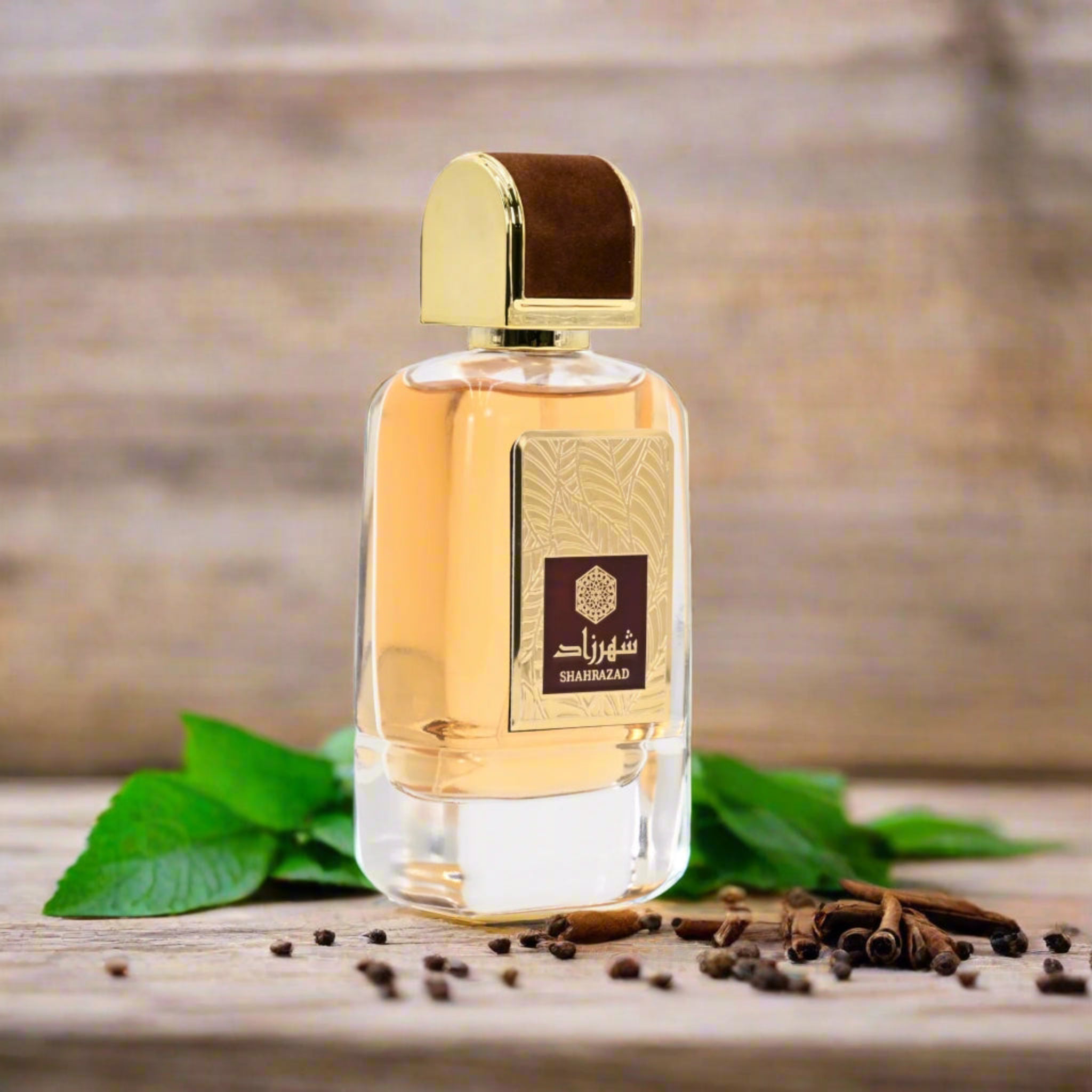 Perfume bottle with gold cap and label on a wooden surface with leaves and spices