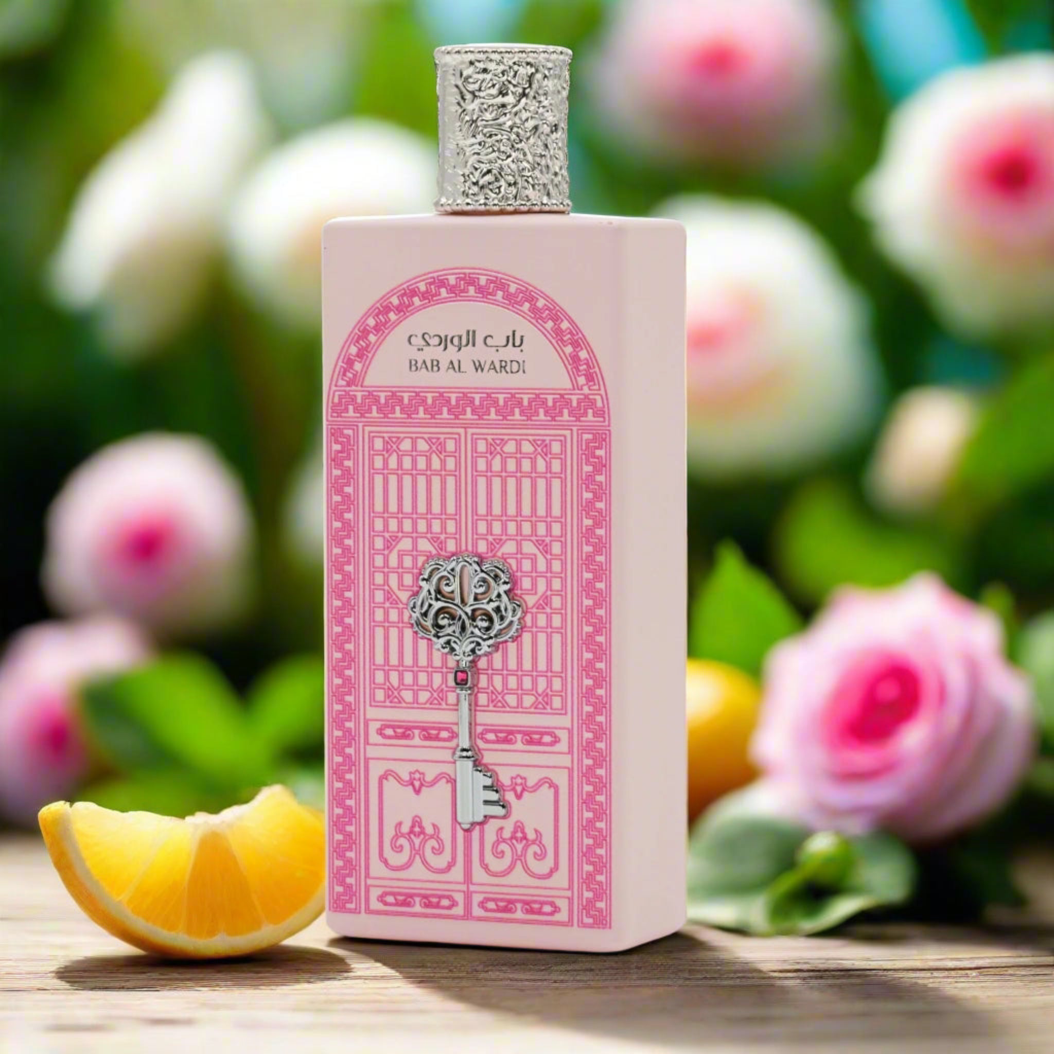 Perfume bottle with pink design on a wooden surface with flowers in the background