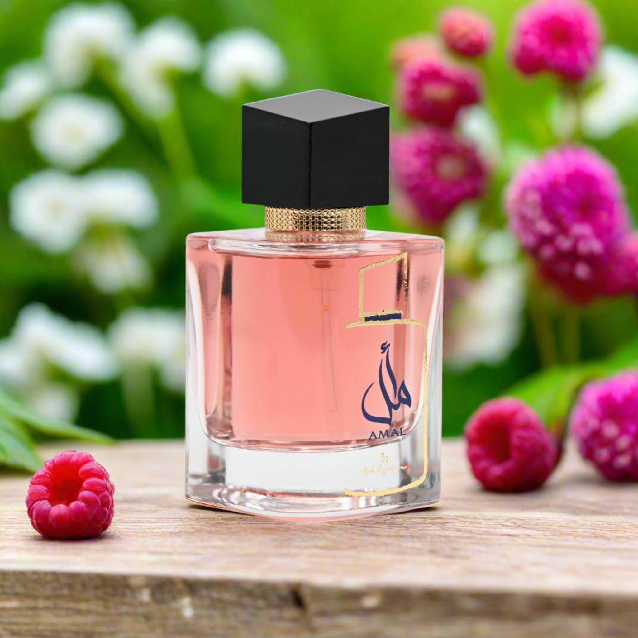 Perfume bottle with a black cap on a wooden surface with flowers and raspberries in the background