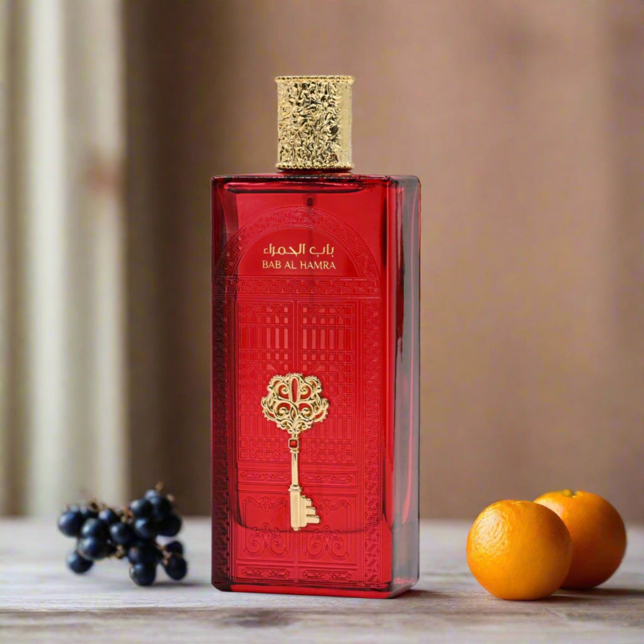 Red perfume bottle with gold accents on a wooden surface with fruits