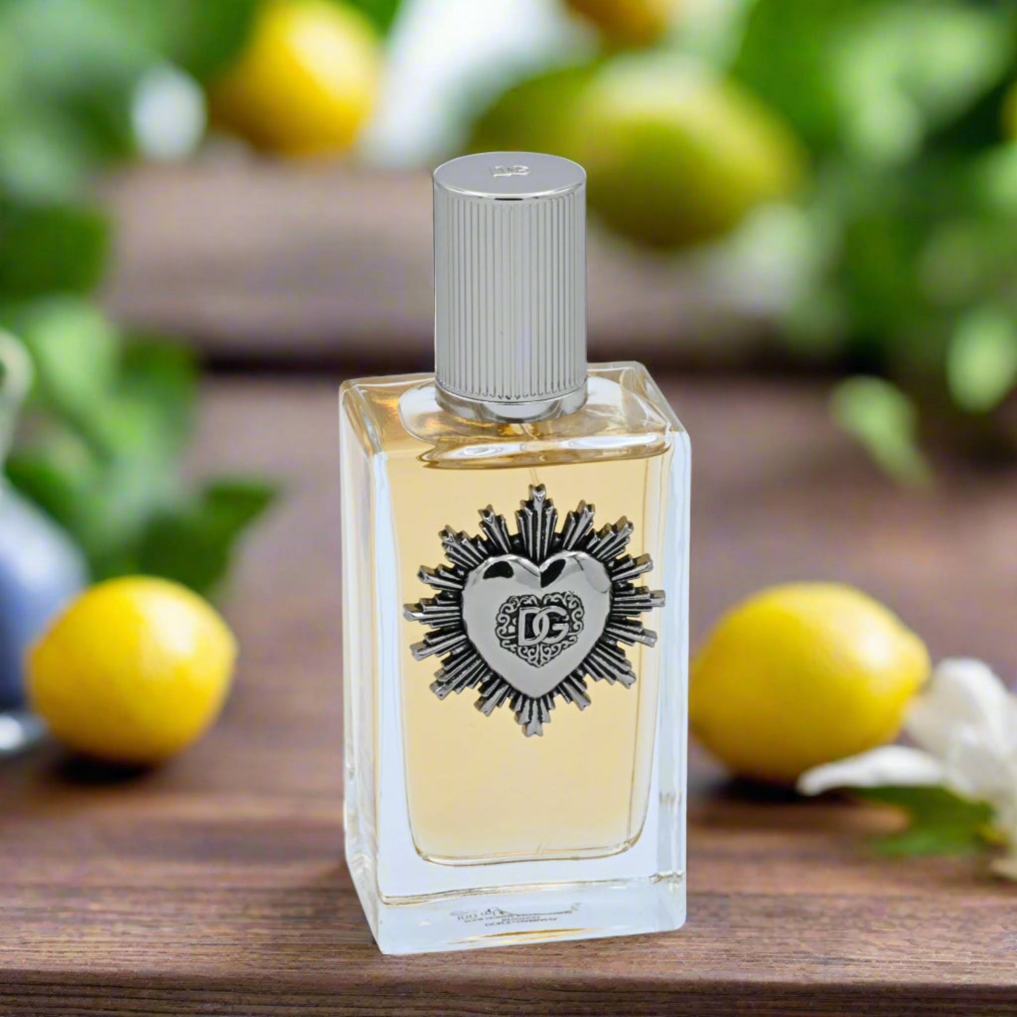 Perfume bottle with decorative label on a wooden surface with lemons and greenery in the background