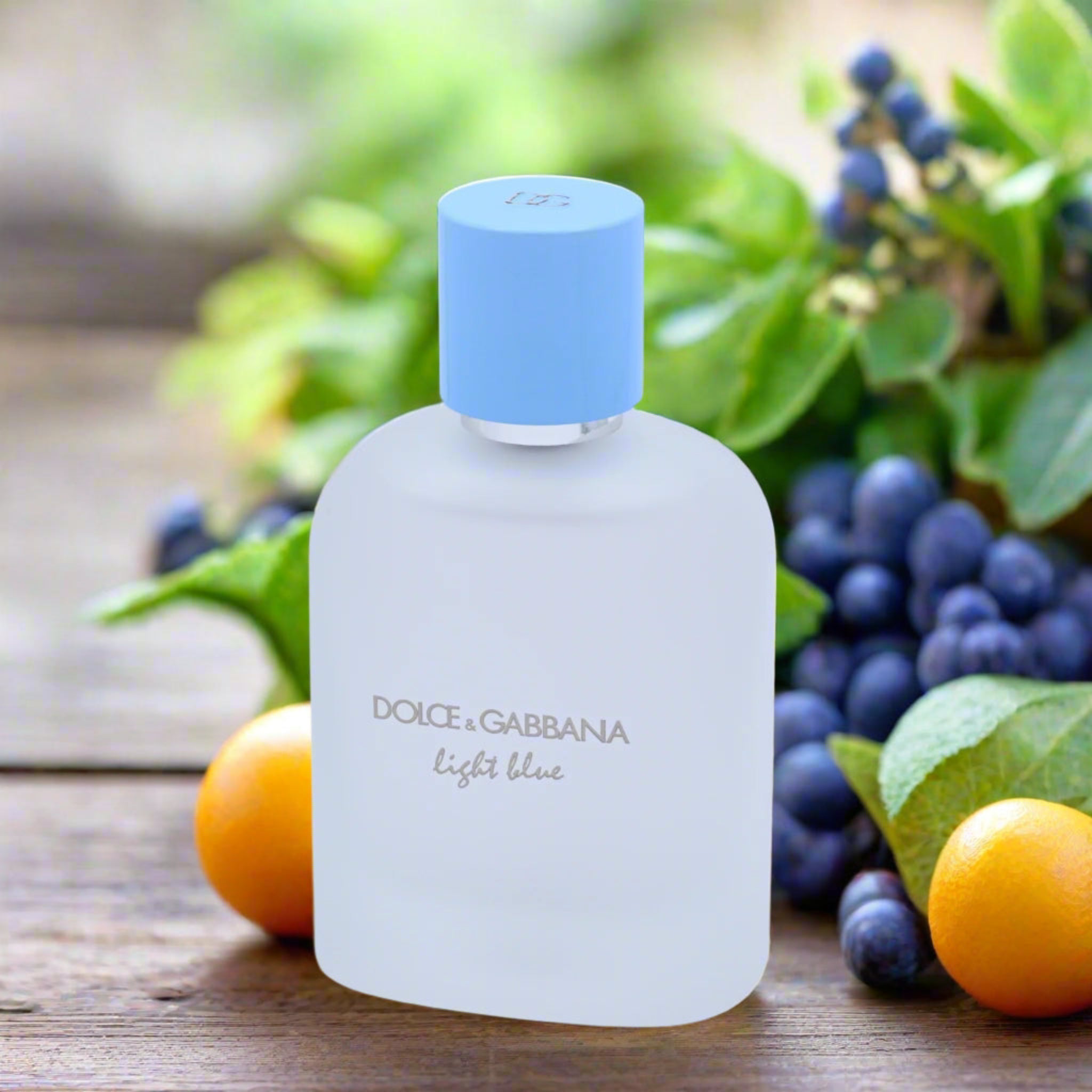 Dolce & Gabbana Light Blue perfume bottle with fruits and greenery on a wooden surface