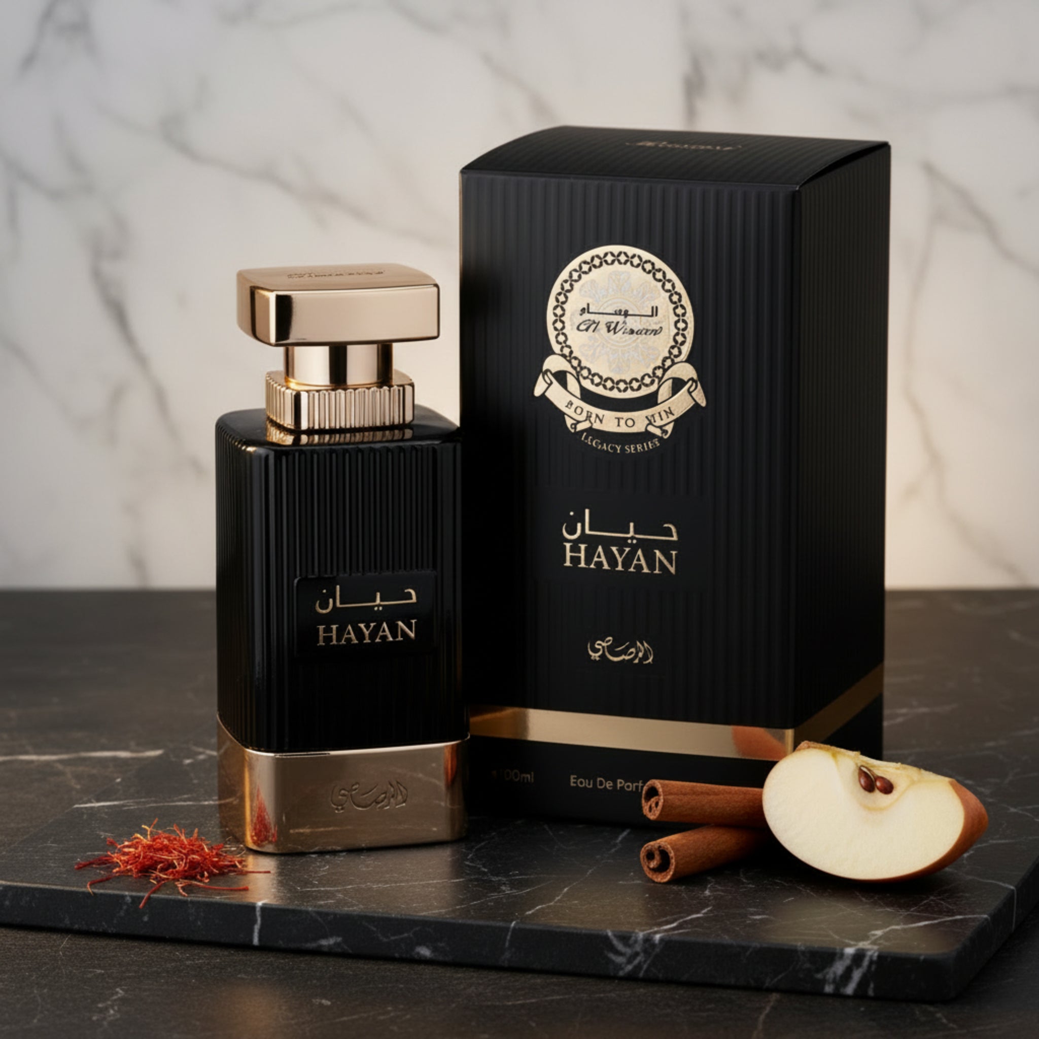 Hayan perfume bottle and packaging on a marble surface with spices and an apple slice.
