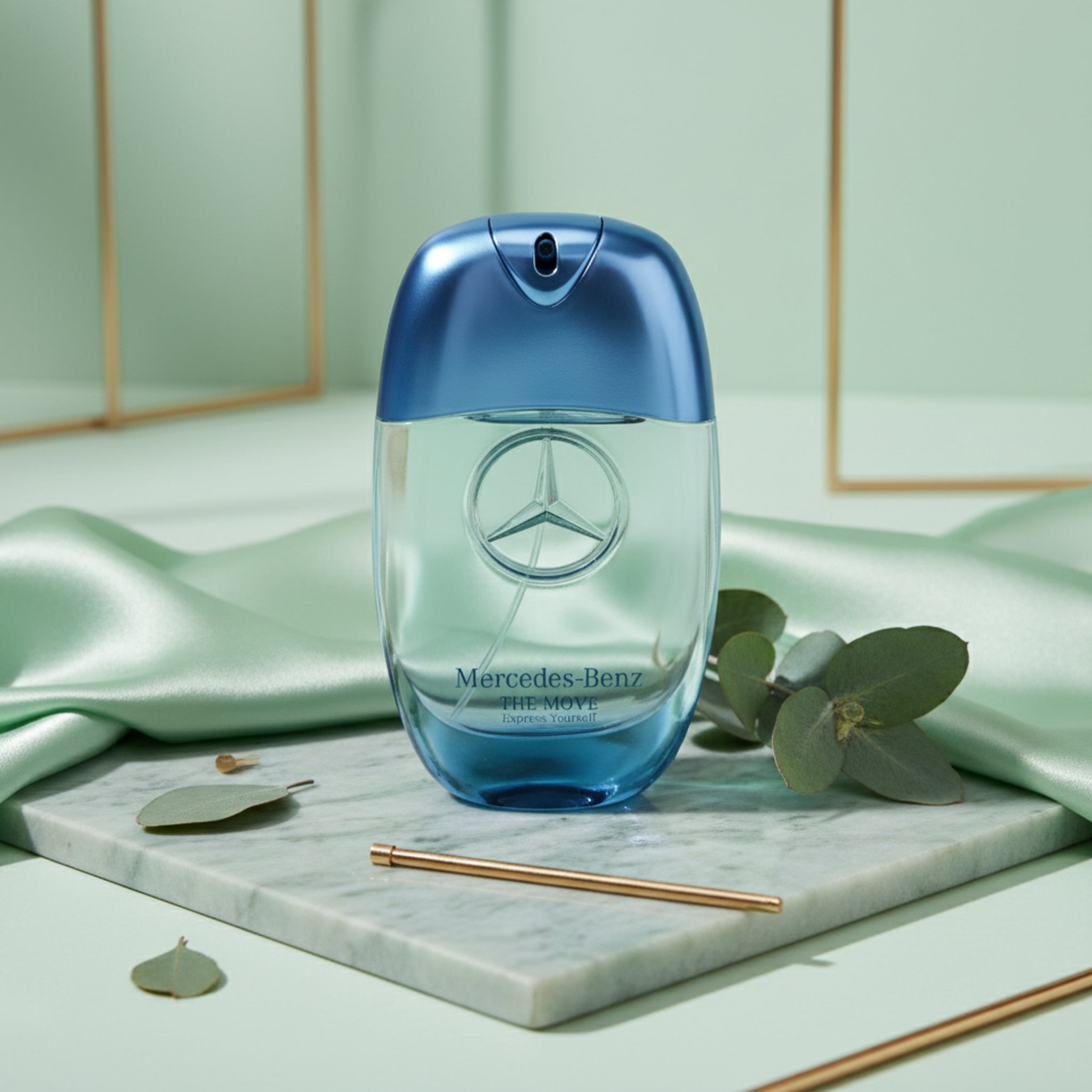 Blue Mercedes-Benz perfume bottle on a marble tray with green leaves and fabric