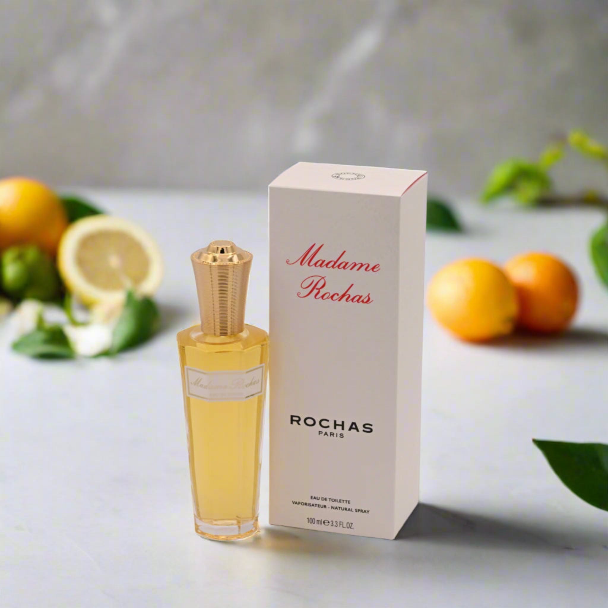 Rochas perfume bottle and packaging with fruits in the background