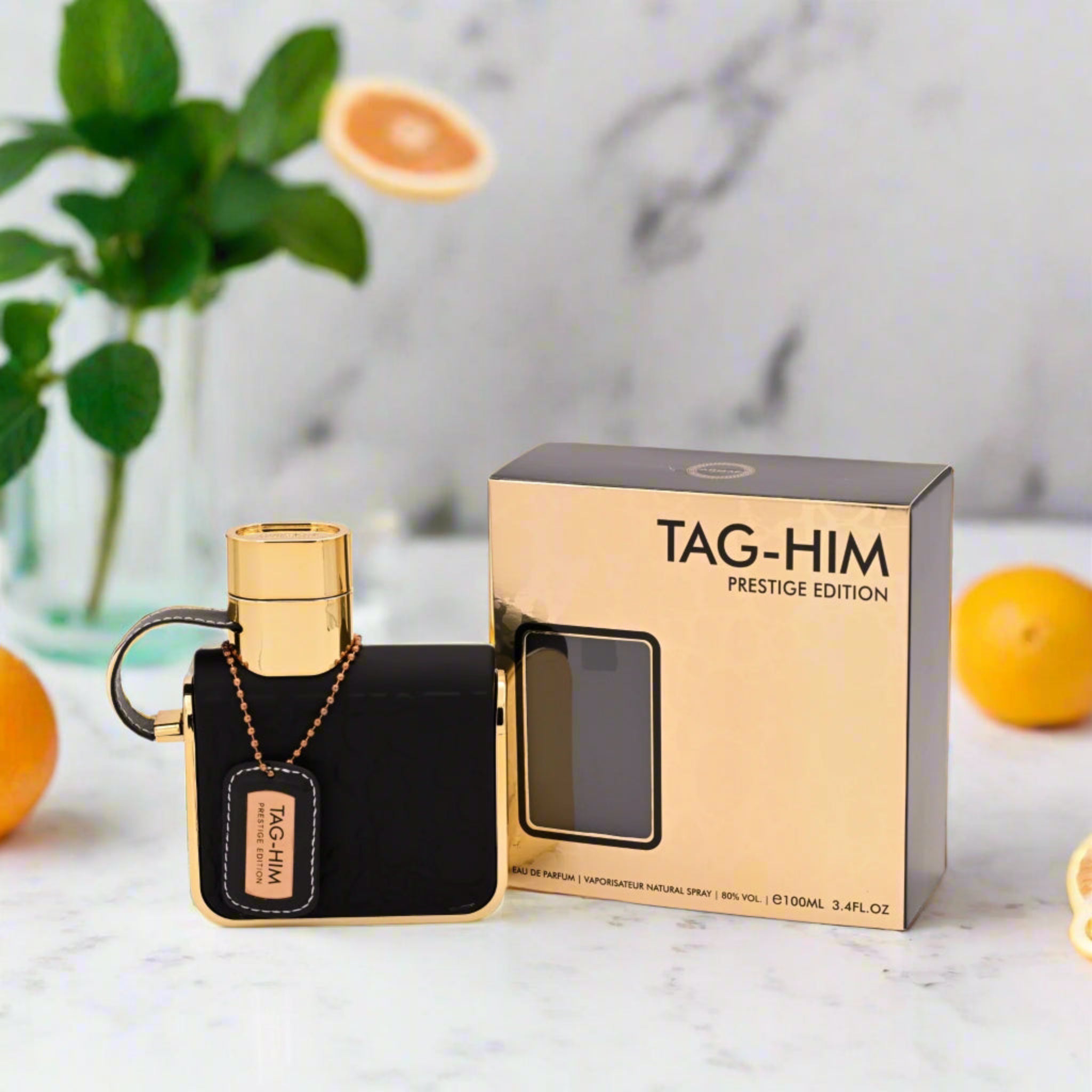 Perfume bottle and packaging with 'TAG-HIM' branding on a marble surface.