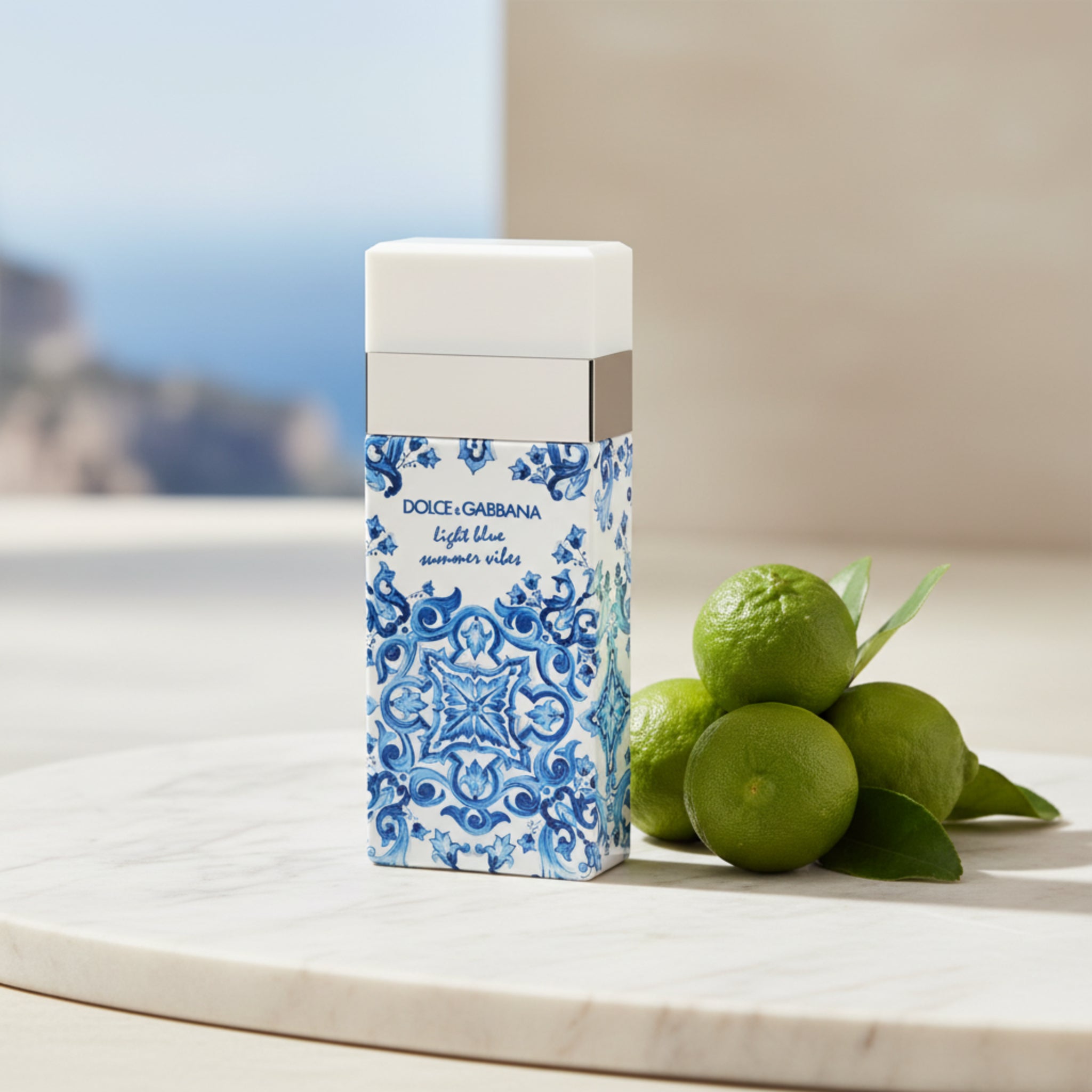 Perfume bottle with blue and white pattern on a white background with bergamots