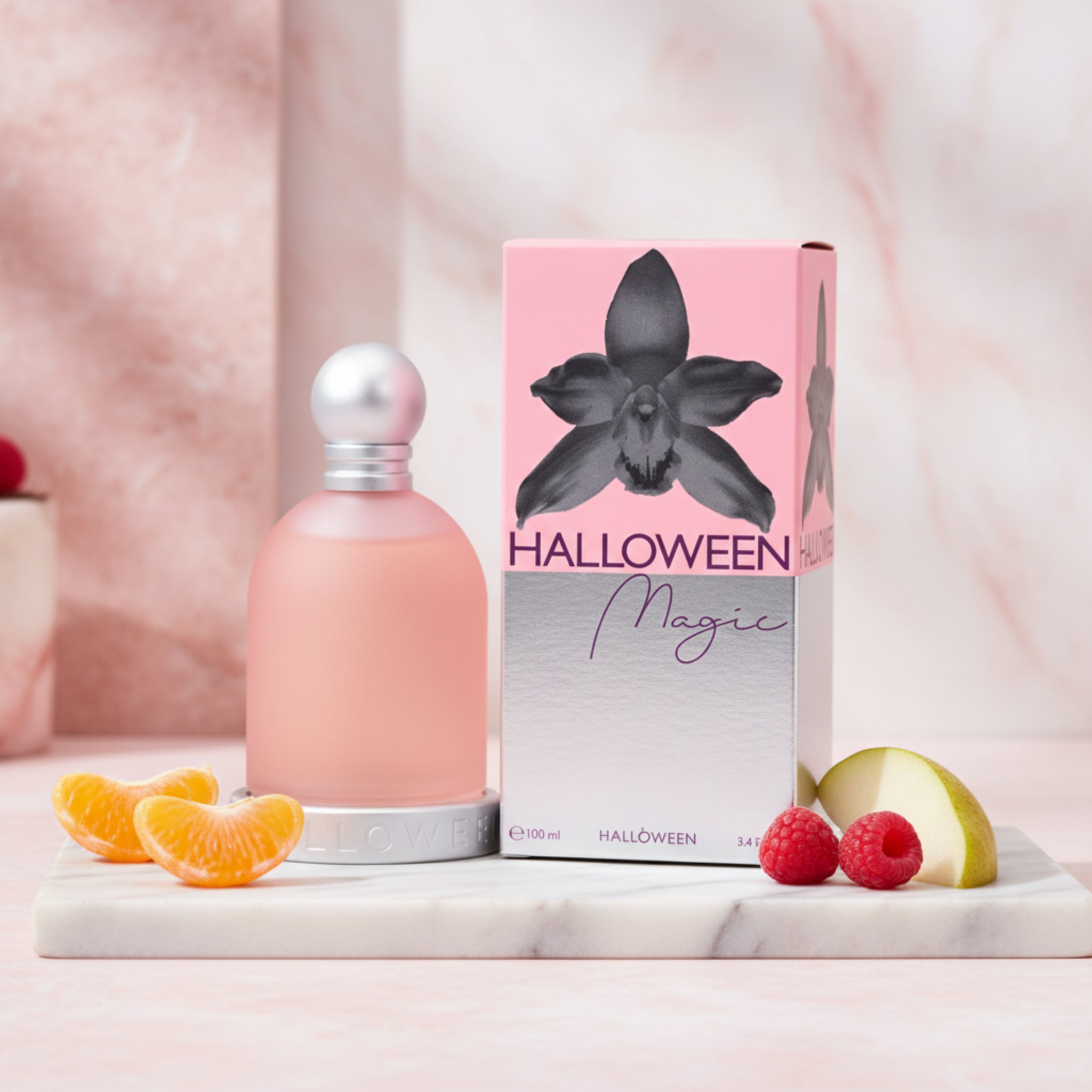 Pink perfume bottle with white cap next to its packaging on a white background