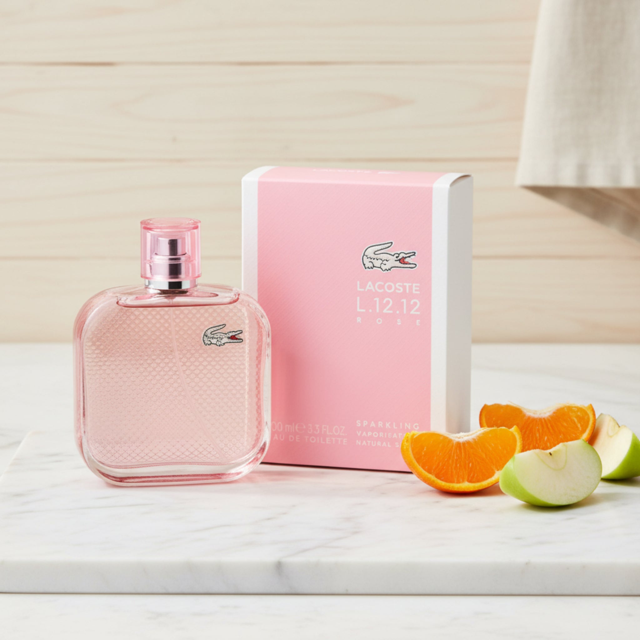 Pink Lacoste perfume bottle and packaging on a white background