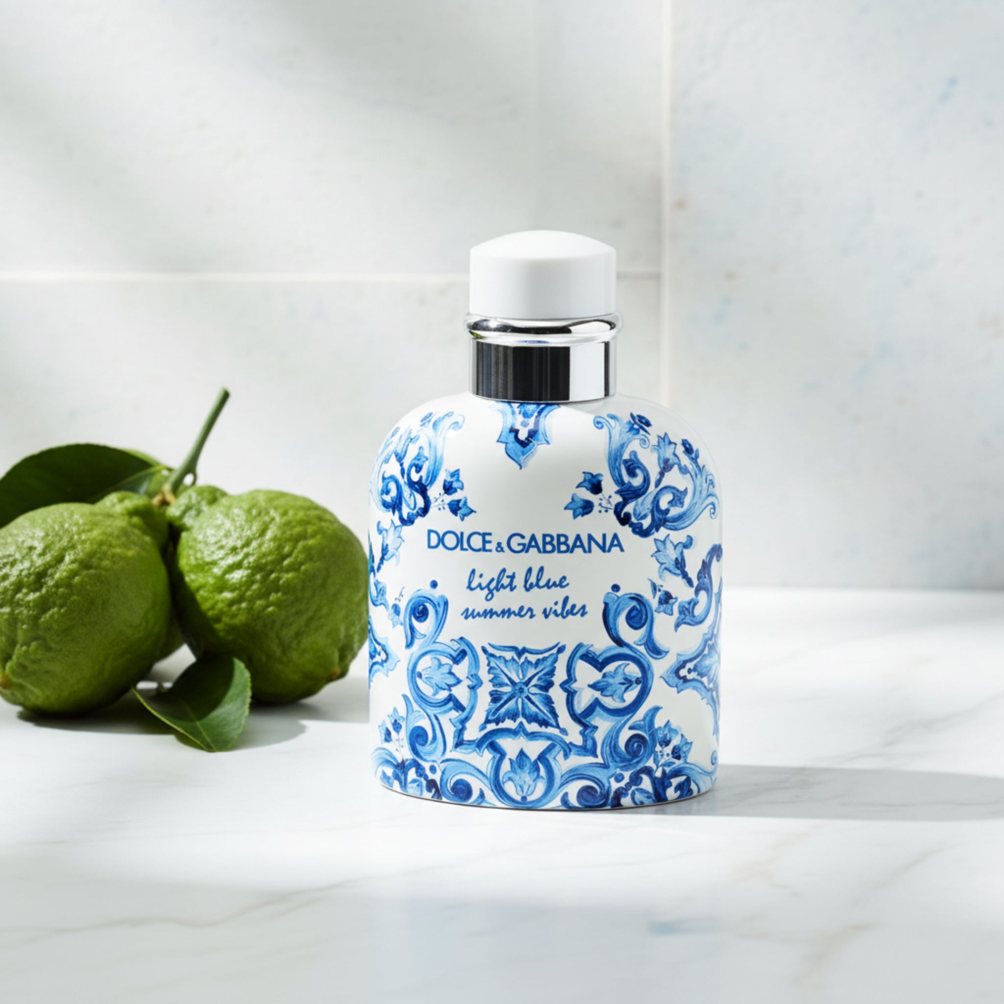 Dolce & Gabbana perfume bottle with blue floral pattern on a white background