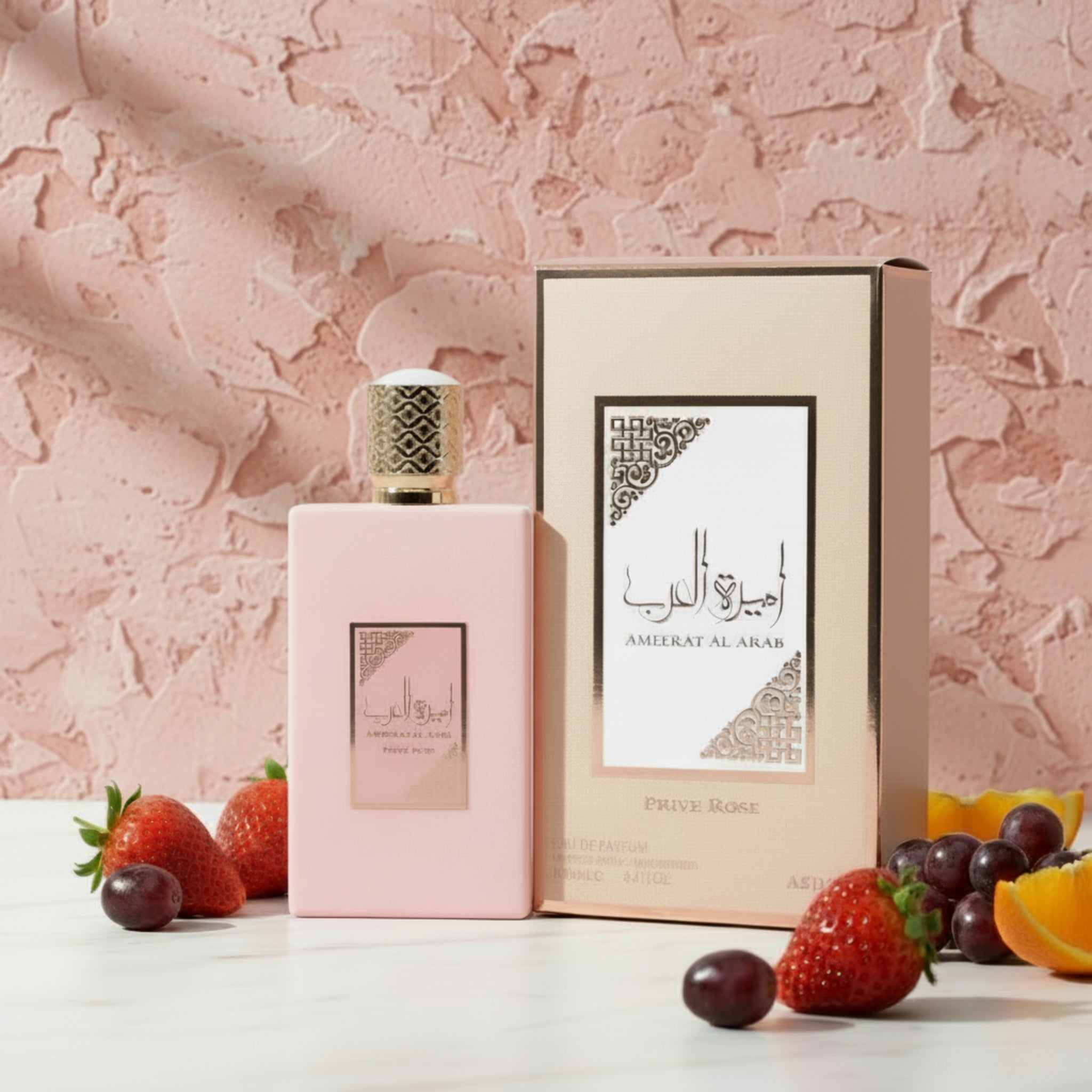 Pink perfume bottle and packaging of Ameerat Al Arab Prive Rose on a white background