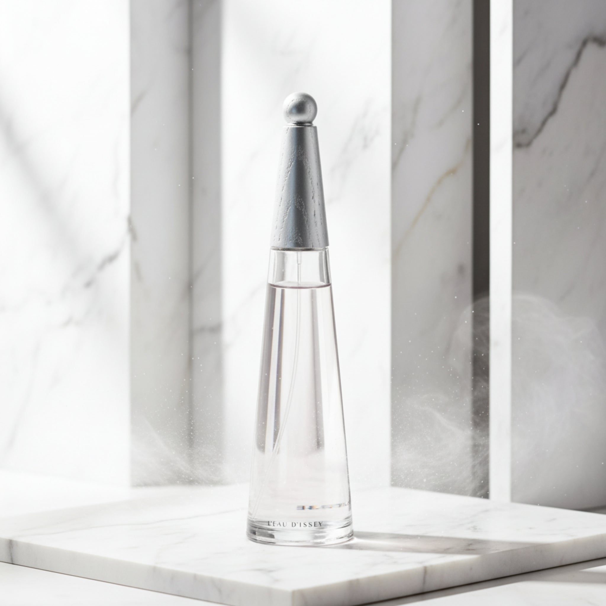 Clear glass perfume bottle with silver cap on a white background