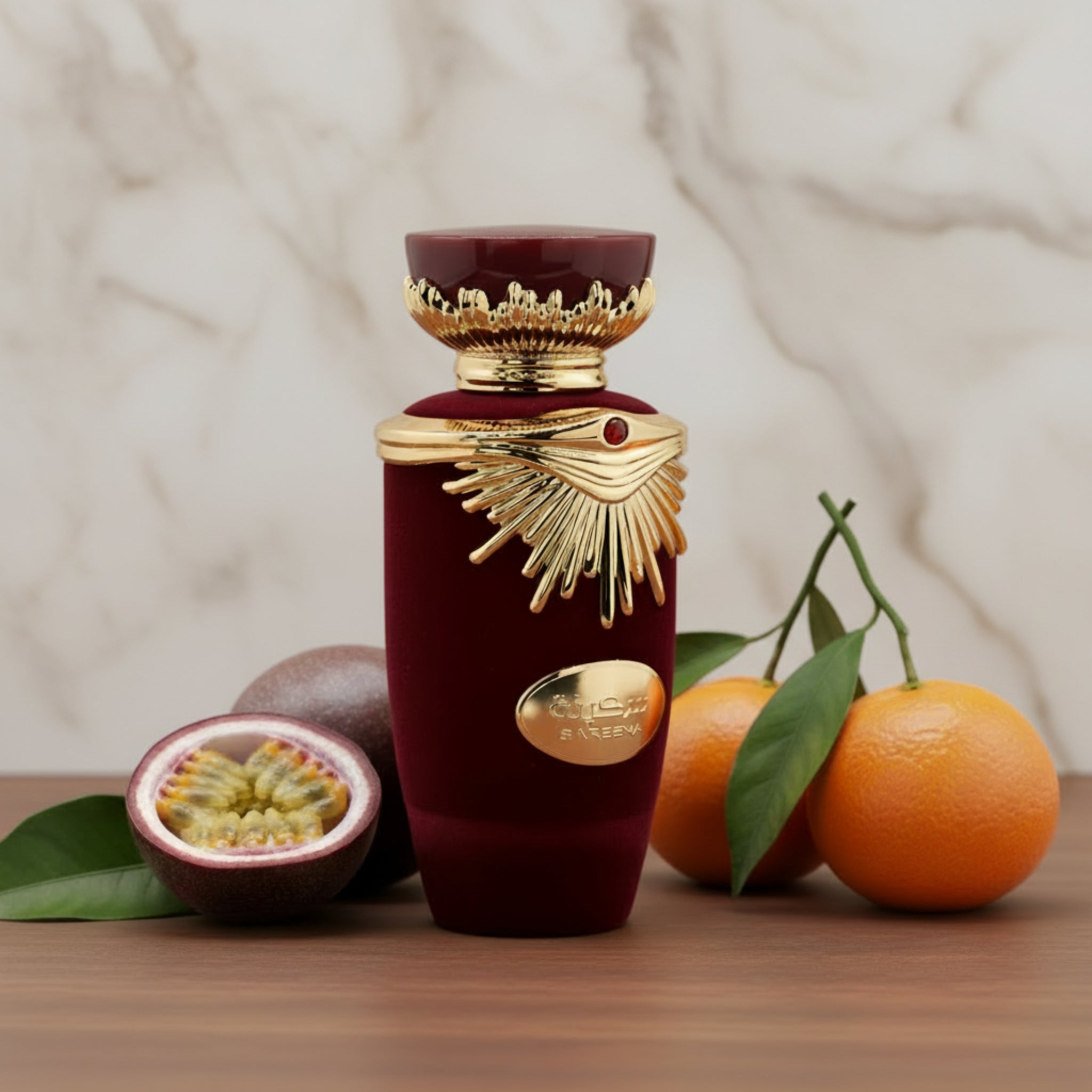 Luxury perfume bottle with gold accents on a wooden surface with fruits and leaves.