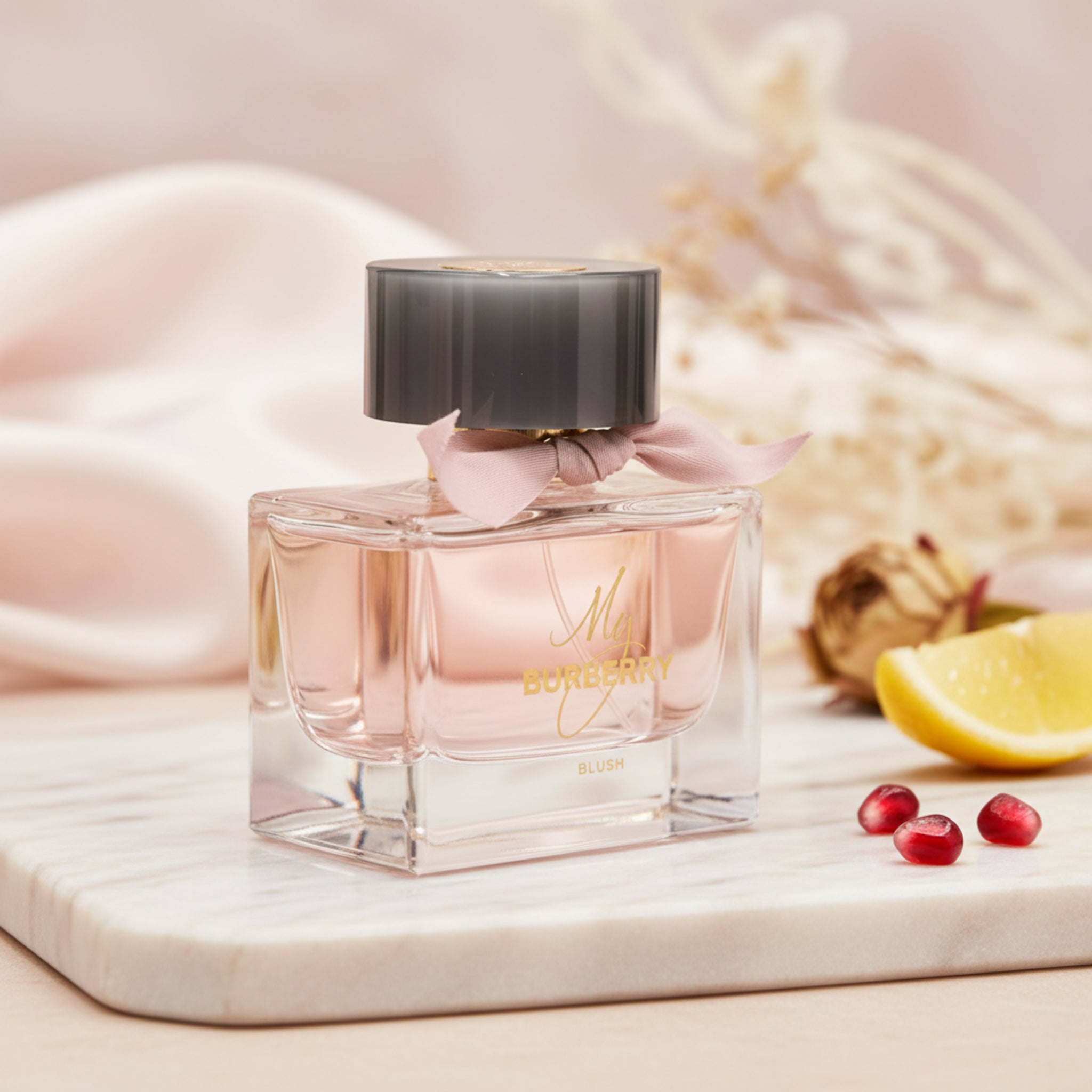 Burberry perfume bottle with pink cap on a white background